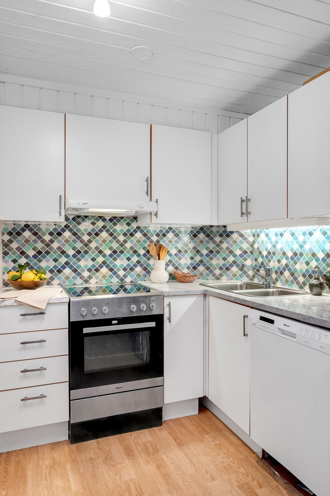 Kjøkken med rikelig skap og benkeplass. Galleribilde