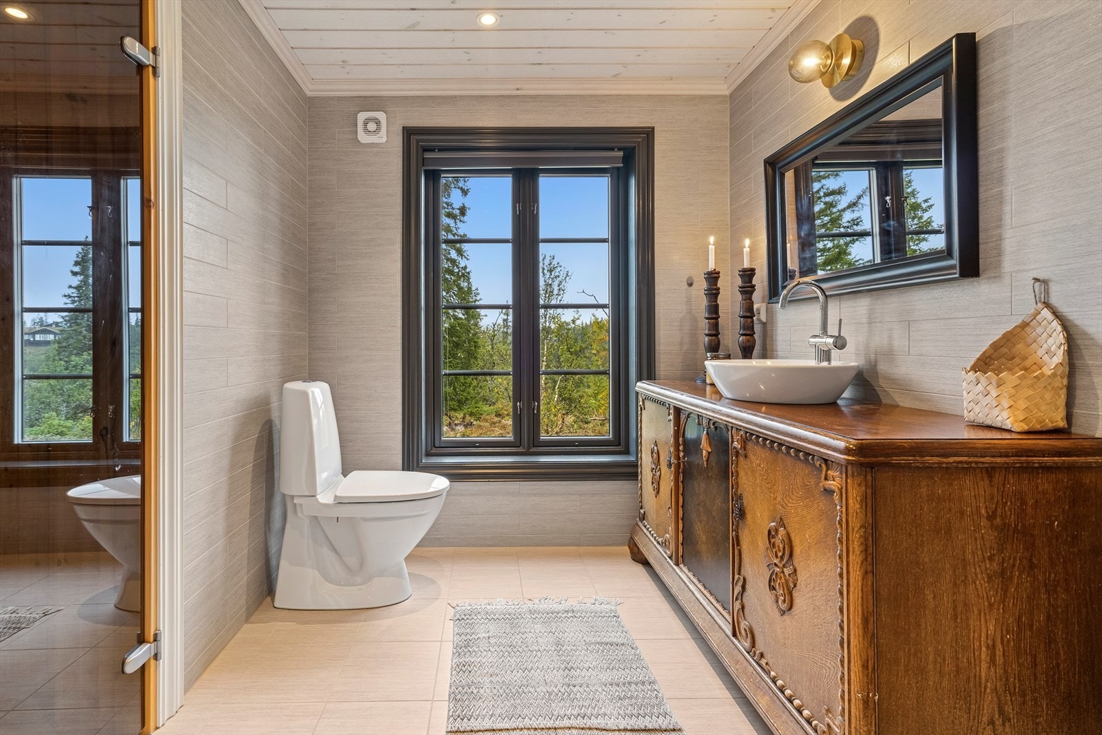 Den runde servanten montert på en eldre skjenk gir et flott og unikt utseende på badet. Fra badet er det glassdør inn til badstue. Galleribilde