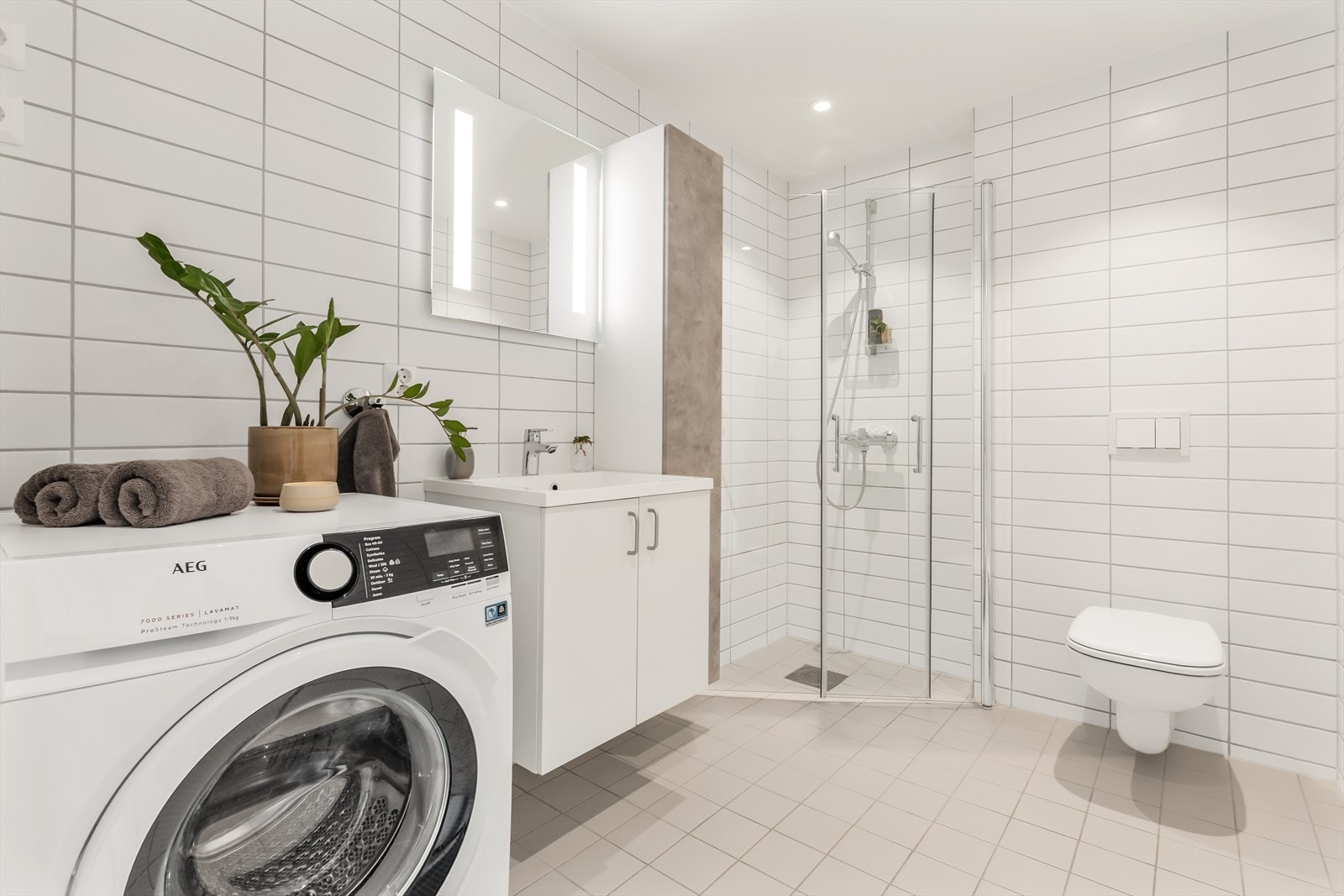 Her er det vannbåren gulvvarme, veggmontert toalett og praktisk opplegg for vaskemaskin Galleribilde