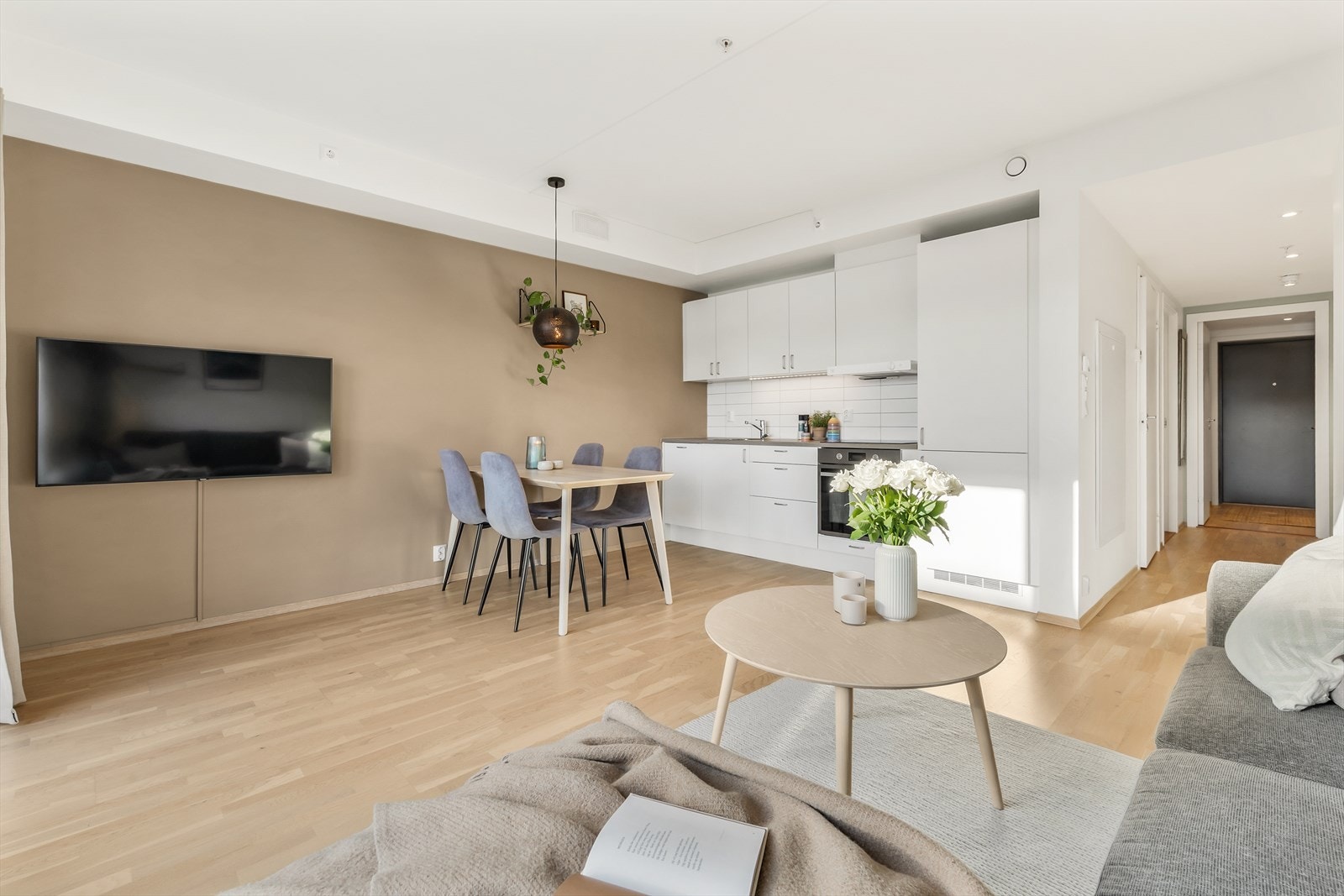 Den åpne løsningen mellom stue og kjøkken skaper en sosial og innbydende sone Galleribilde