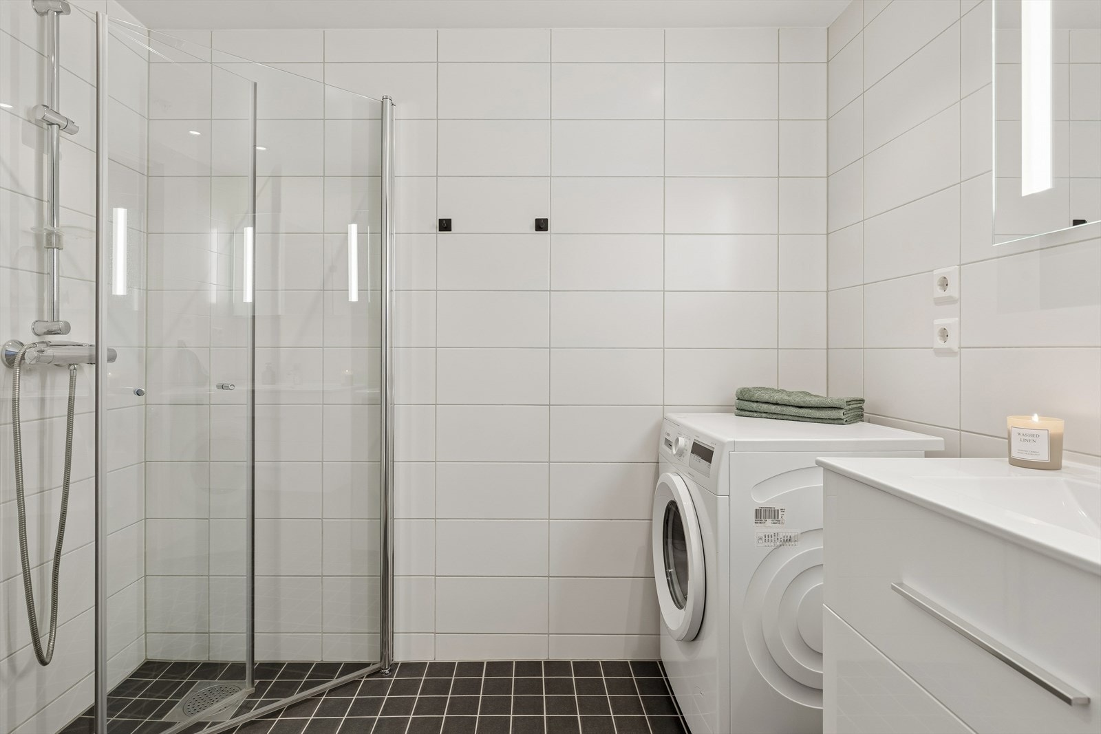 Flislagt bad med gulvvarme for økt komfort og opplegg for vaskemaskin. Galleribilde