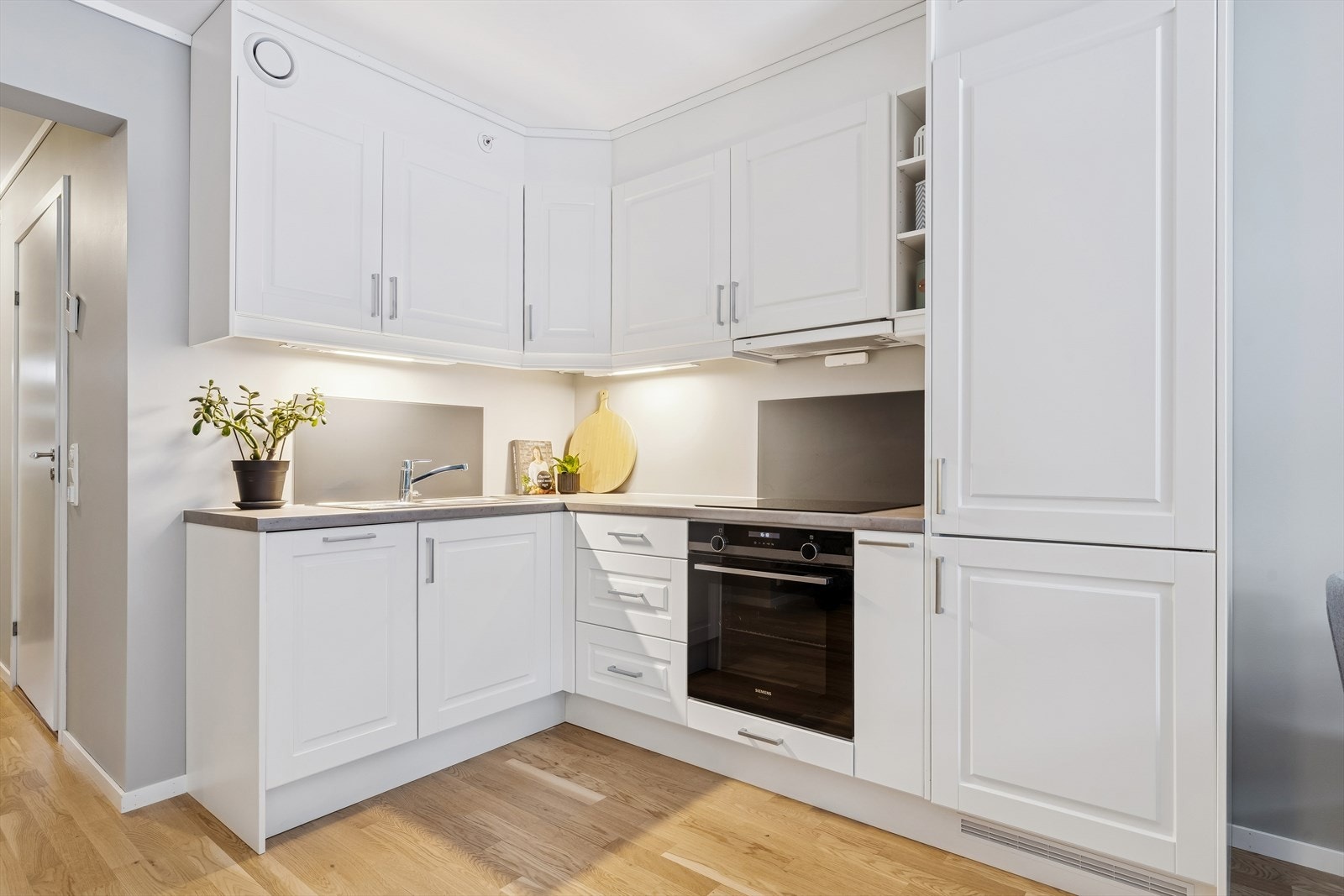 Kjøkken med trivelig spiseplass og integrerte hvitevarer. Galleribilde