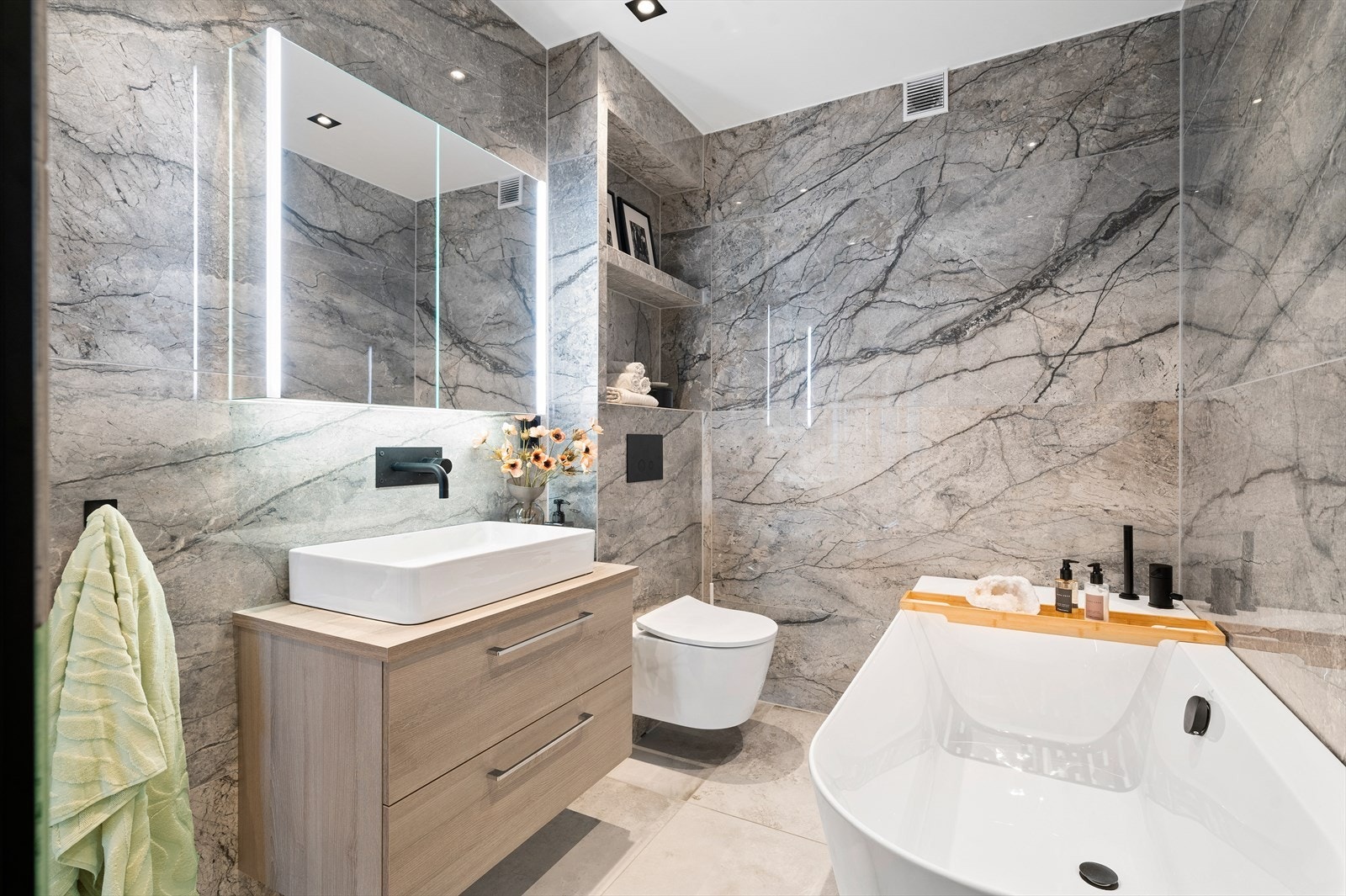 Badet har flislagte vegger med storformat fliser som gir et luksuriøst og helhetlig inntrykk. Galleribilde