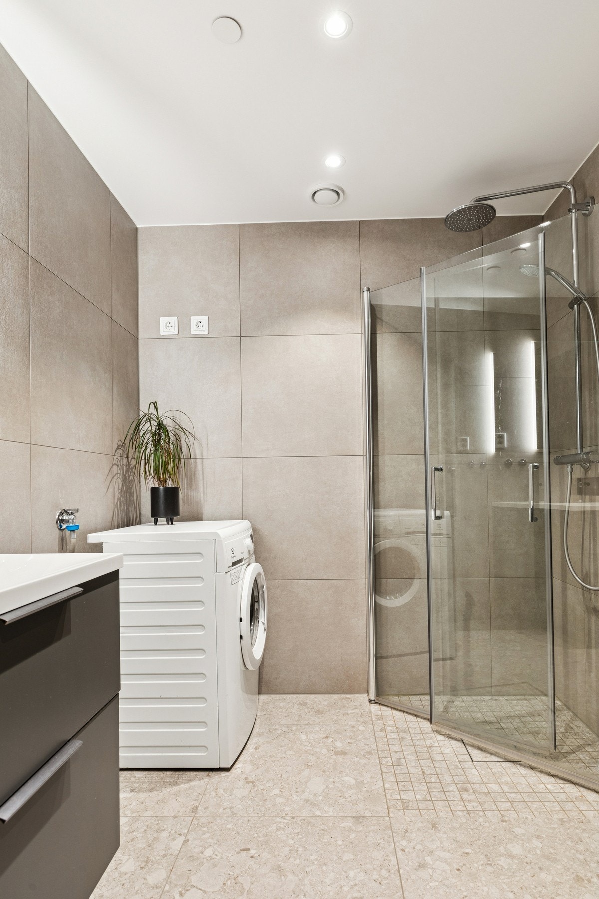 Badet er delikat og helfliset fra byggeår, med gulvvarme, vegghengt toalett, dusjhjørne med både regndusj og hånddusj, samt opplegg for vaskemaskin Galleribilde