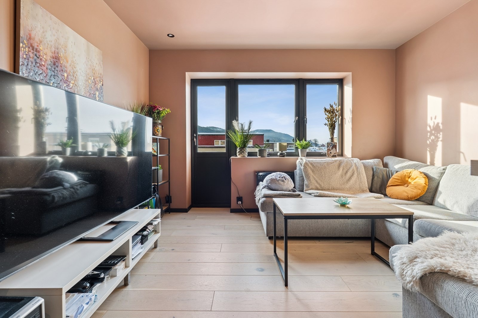 Leiligheten har en åpen og sosial løsning mellom stue og kjøkken, oppgradert i 2024. Galleribilde