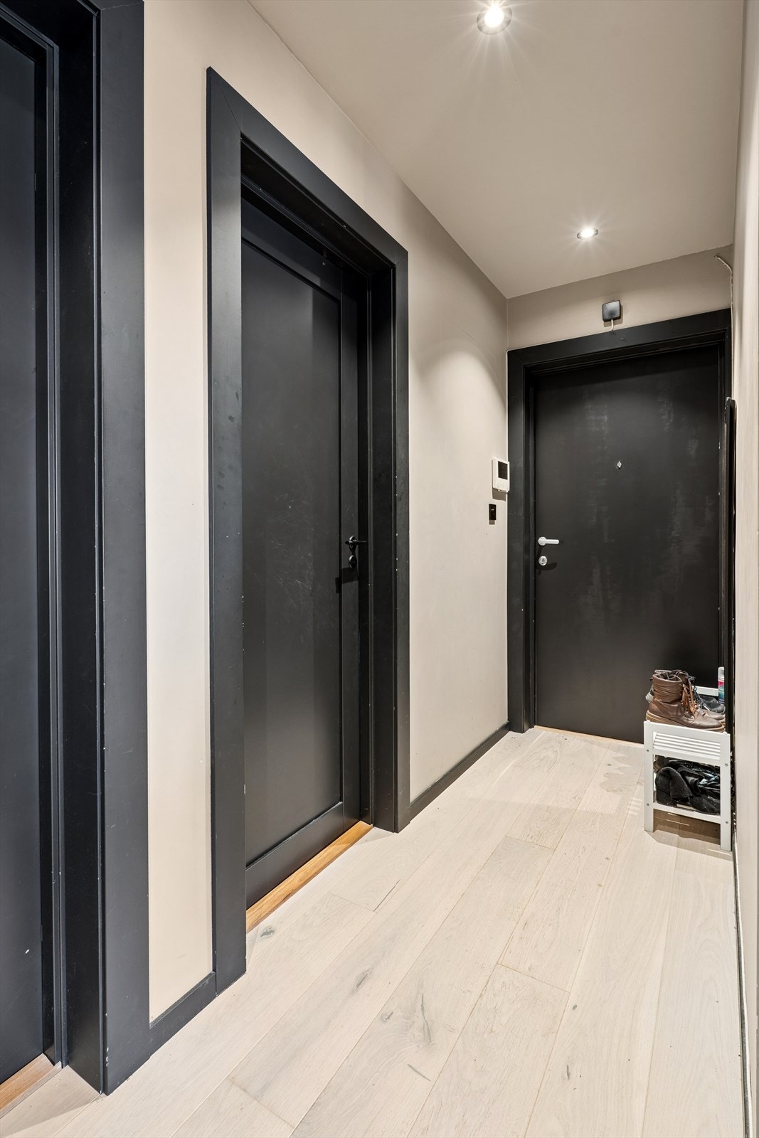 Innbydende entré med malte fyllingsdører som leder videre inn i boligens øvrige rom. Galleribilde