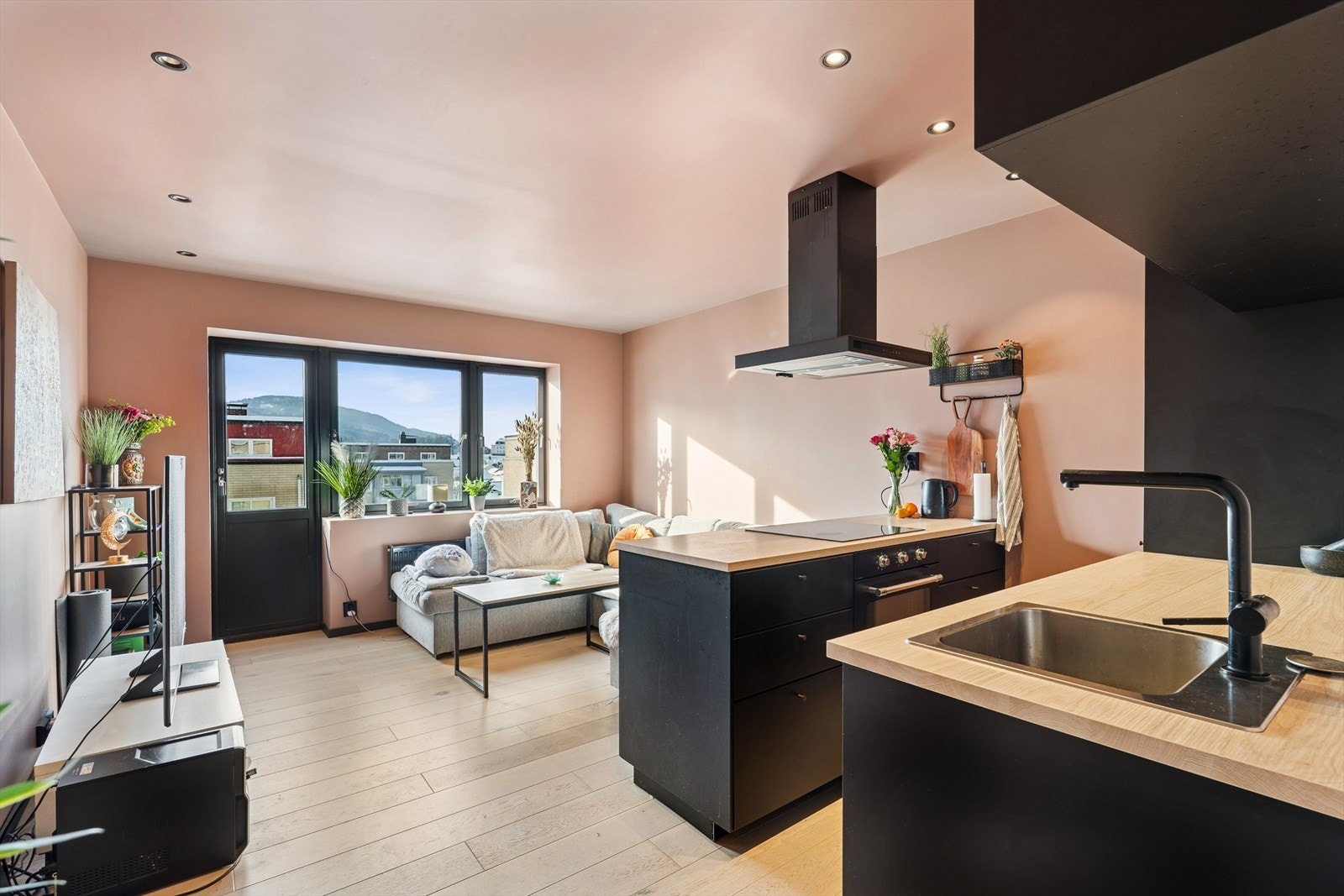 Kjøkkenet er smart integrert i stuen, noe som skaper et sosialt samlingspunkt i leiligheten. Galleribilde