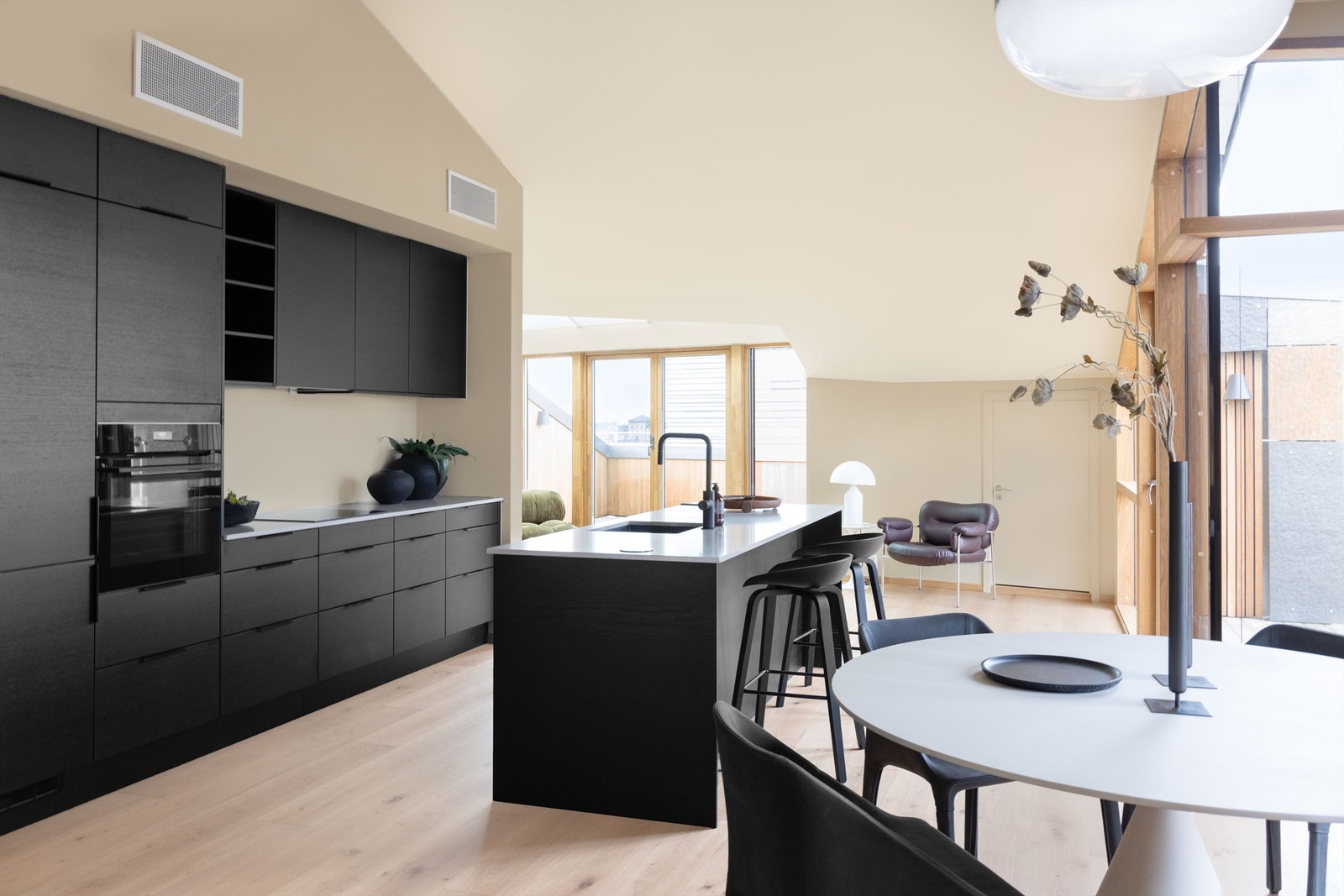 Leiligheten har en lys og åpen stue- kjøkkenløsning med kjøkkenøy og god plass for spisebord. Galleribilde