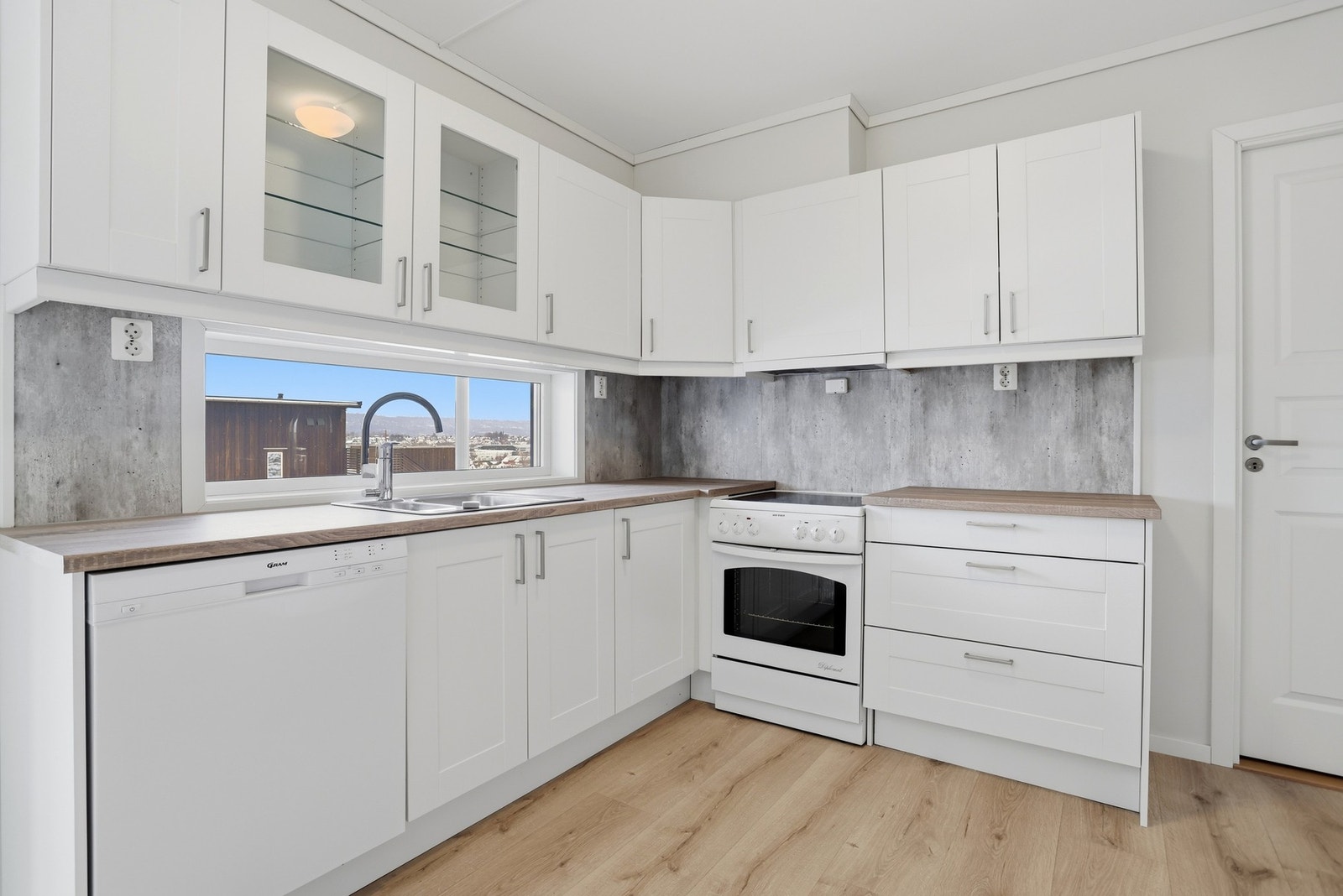 Kjøkkeninnredningen har glatte fronter og laminert benkeplate. Galleribilde