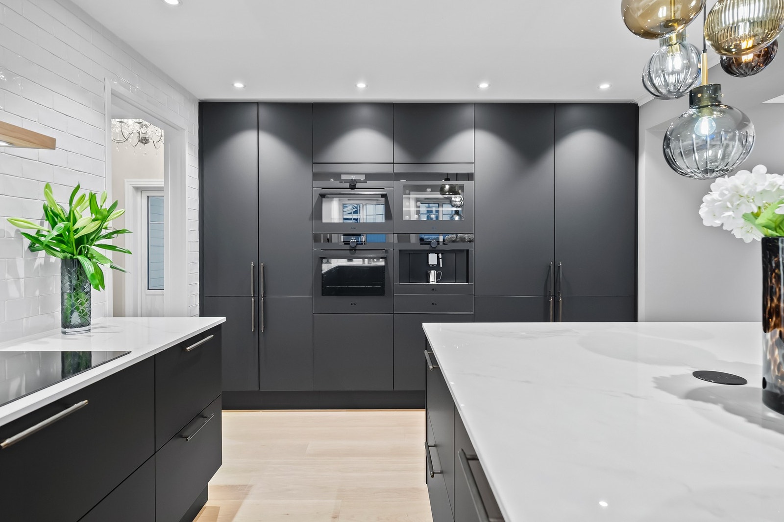 Flislagt vegg over benkeskap og nøye tilpasset ventilator understreker det gjennomførte uttrykket. Galleribilde