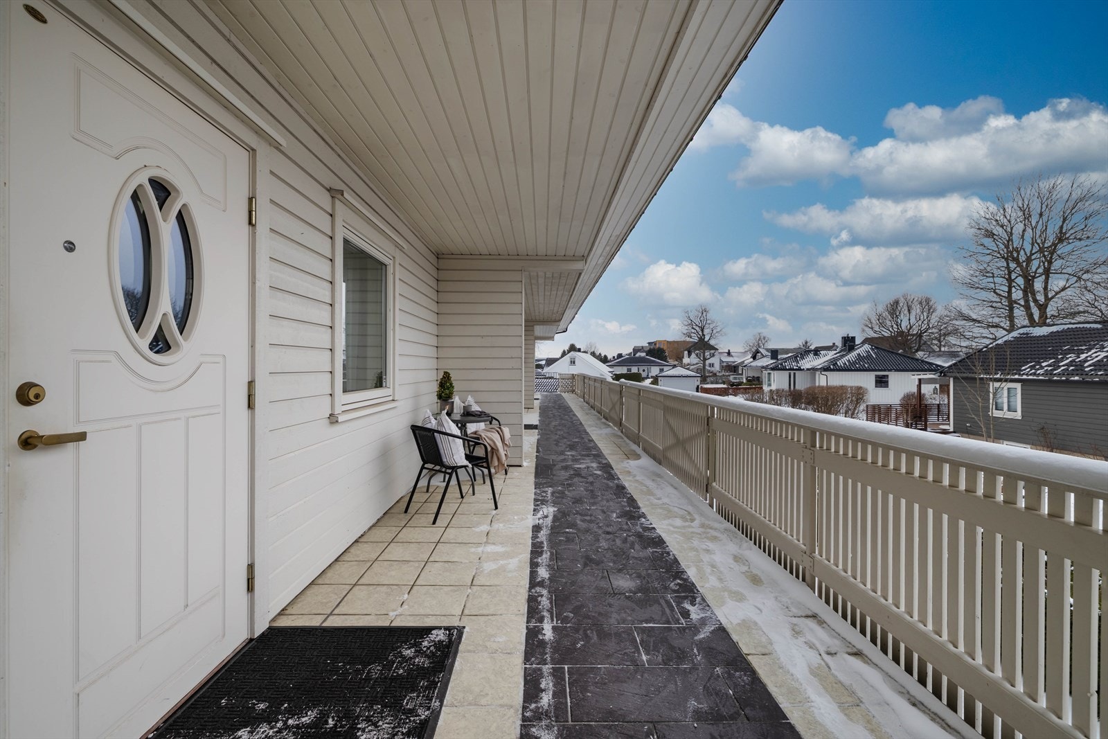 Ved inngangspartiet er det også en fin uteplass med skjermvegg mot nabo, flislagt dekke (med varmekabler), utebelysning og plass for et hyggelig kafésett. Galleribilde