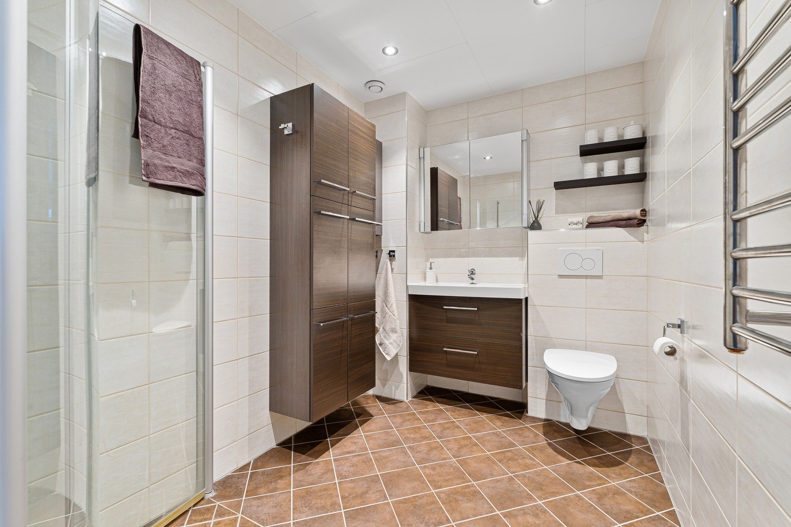 Lekkert, flislagt baderom med elektrisk gulvvarme og downlights i tak. Galleribilde