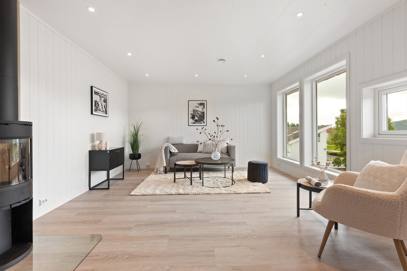 Lys og romslig stue med moderne overflater og vedovn Galleribilde