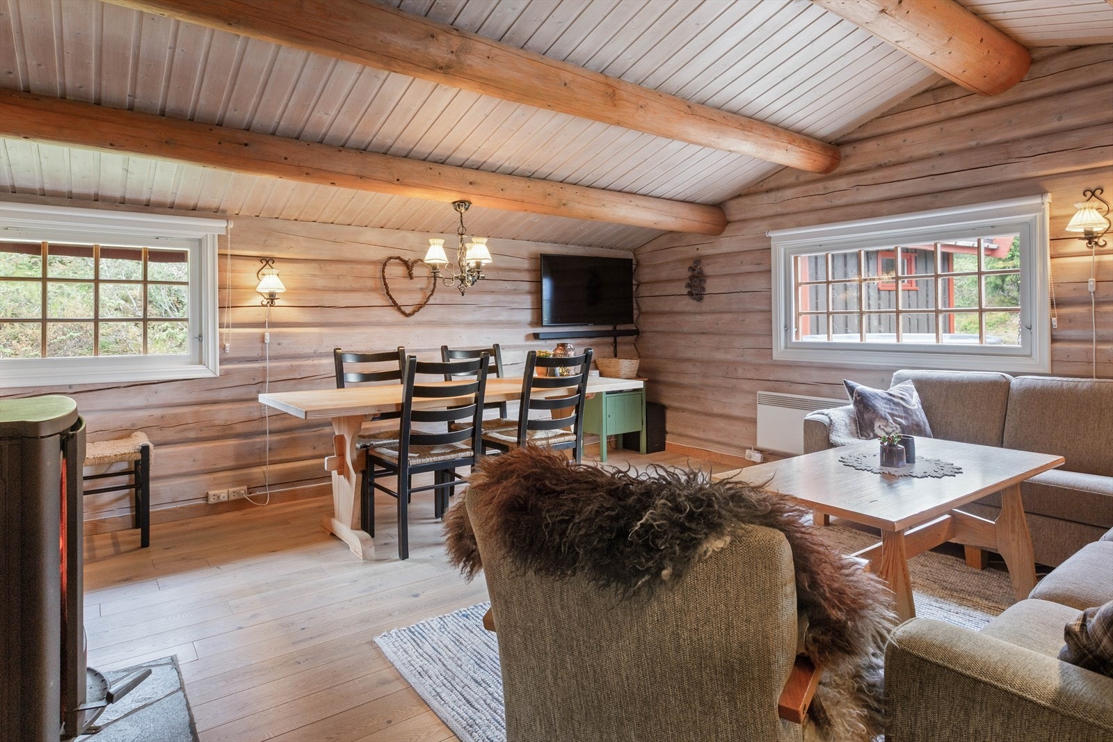 Det er god plass til både sofa- og spisegruppe, og en stilig peisovn med innsyn, gir lun og god varme til rommet. Galleribilde