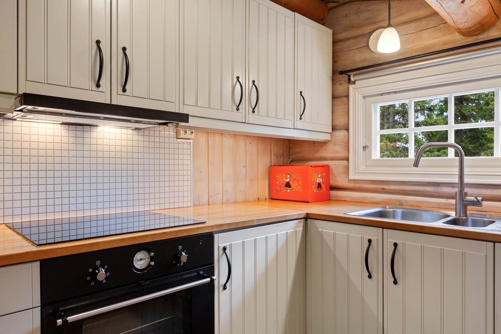 På veggen mellom koketopp og overskap er det montert plate, noe som gjør det enkelt å holde rent. Galleribilde