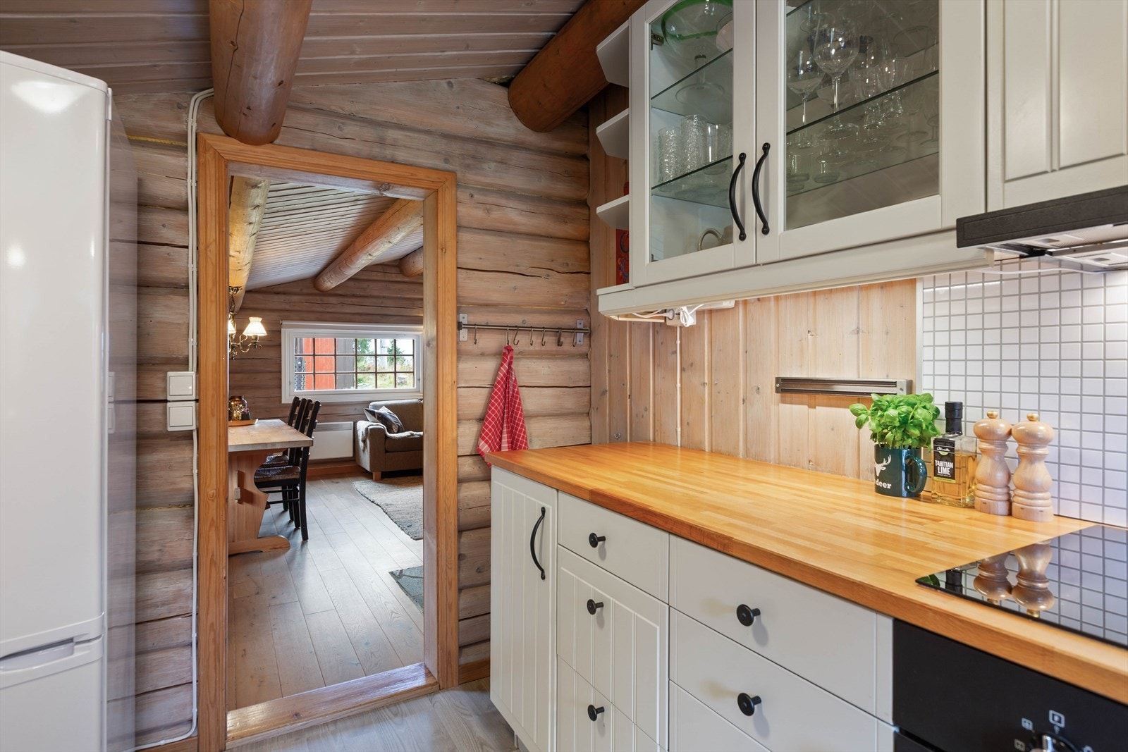 Kjøkkeninnredningen har integrerte hvitevarer med komfyr, koketopp og ventilator. Galleribilde