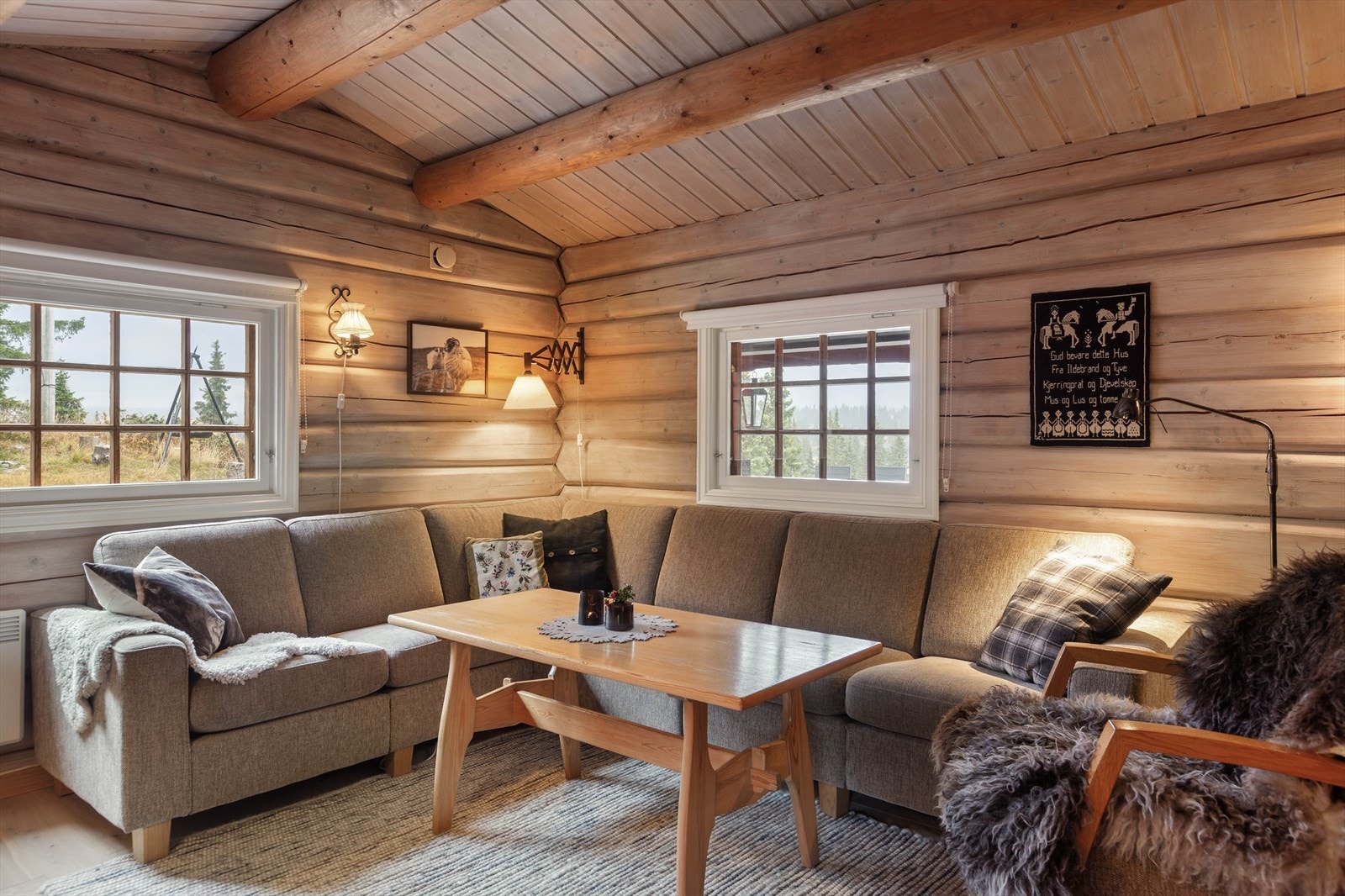 Her er det fine vegger i laftet tømmer og vakkert eikegulv i heltre. Det er god plass til både sofa- og spisegruppe, og en stilig peisovn med innsyn, gir lun og god varme til rommet. Galleribilde