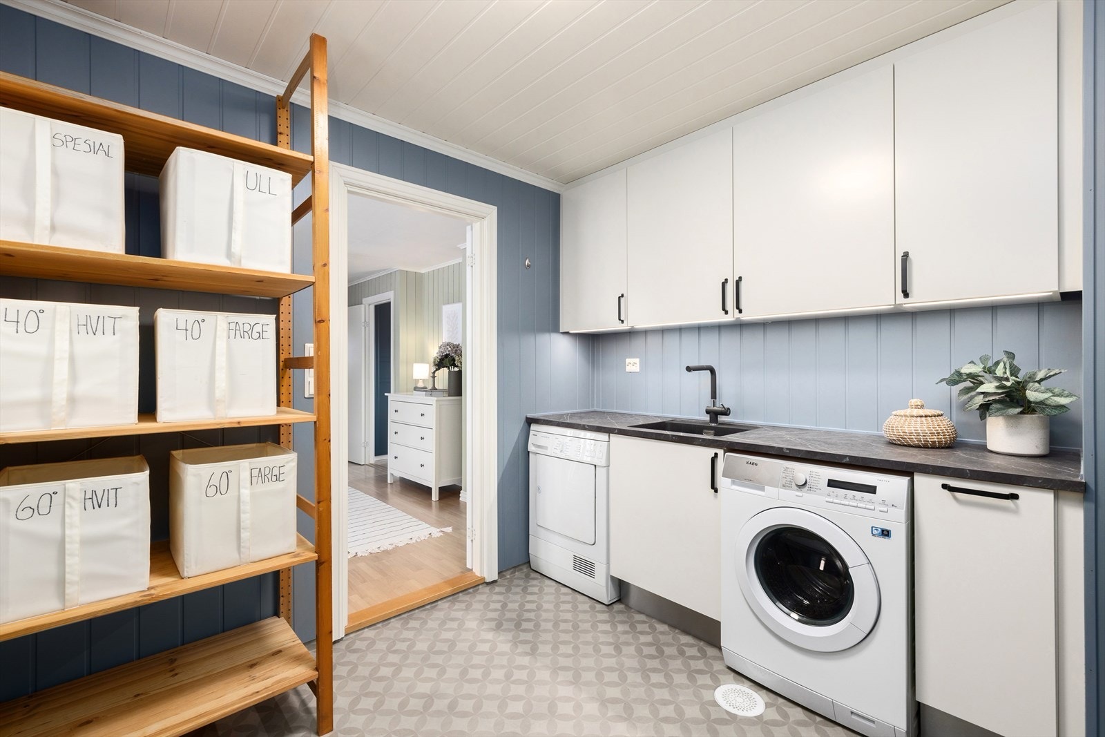 Praktisk vaskerom med smart vaskeromsinnredning og opplegg for både vaskemaskin og tørketrommel. Varmekabler i gulv. Galleribilde
