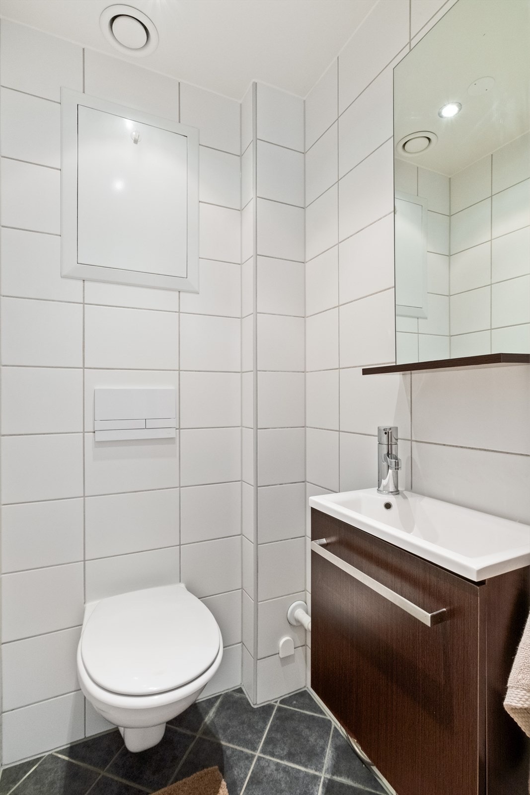 Leiligheten har i tillegg et eget toalettrom, tilsvarende flislagt som badet. Toalettrommet er innredet med vegghengt toalett og nedfelt servant. Galleribilde