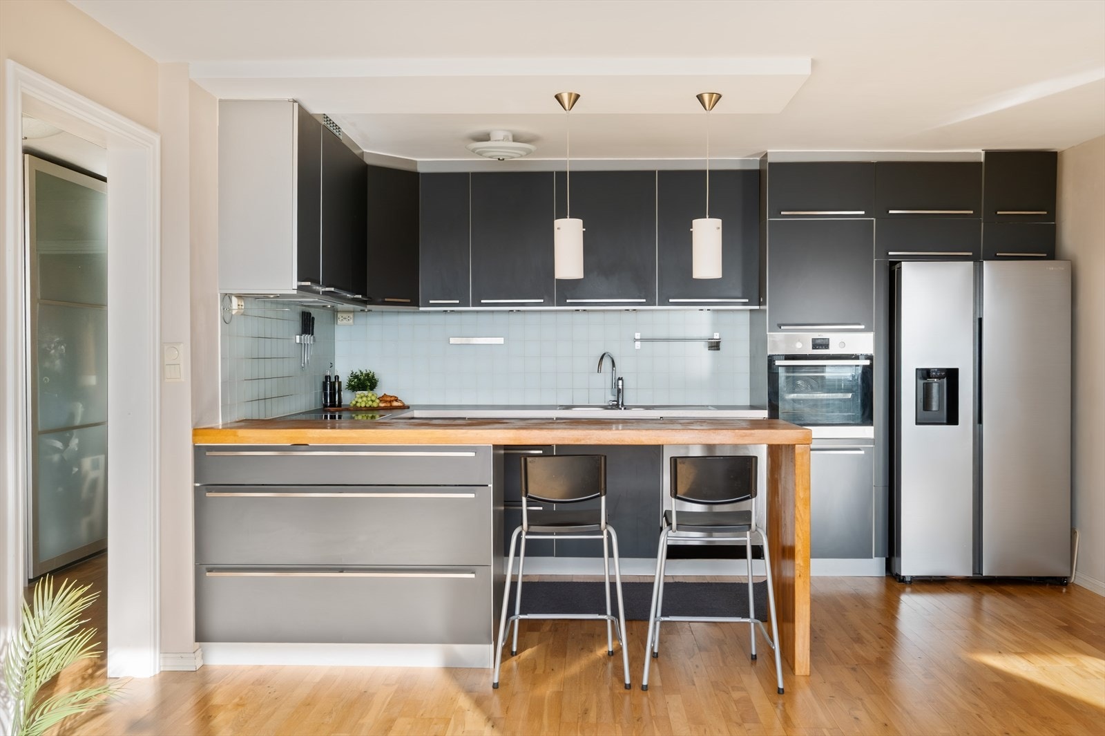 Moderne kjøkkeninnredning med sorte fronter. Spiseplass integrert i kjøkkenet Galleribilde