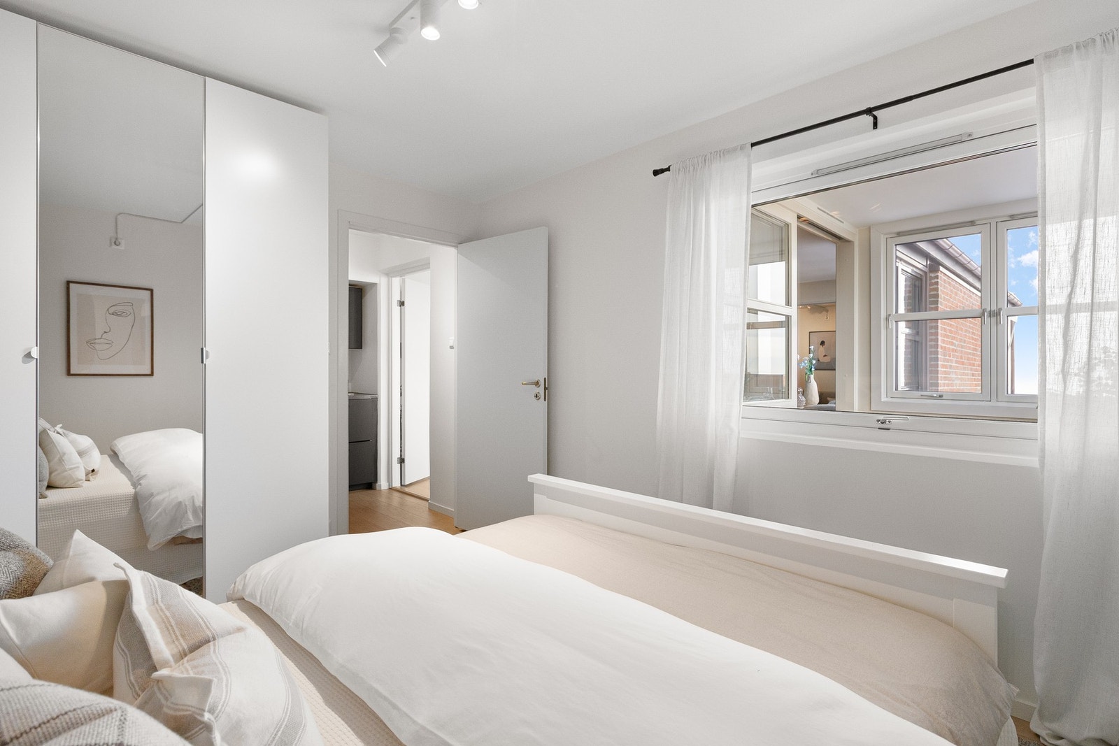 Garderobeskap med glatte fronter og én speilfront sørger for god oppbevaring og en luftig romfølelse. Galleribilde