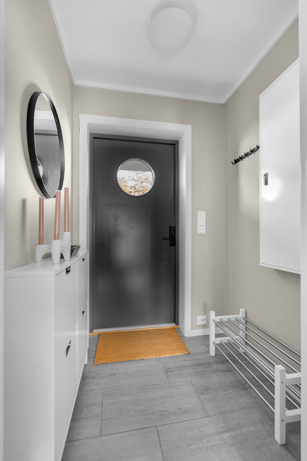 Velkommen inn i en praktisk entré med flislagt gulv og god plass til yttertøy og sko. Galleribilde