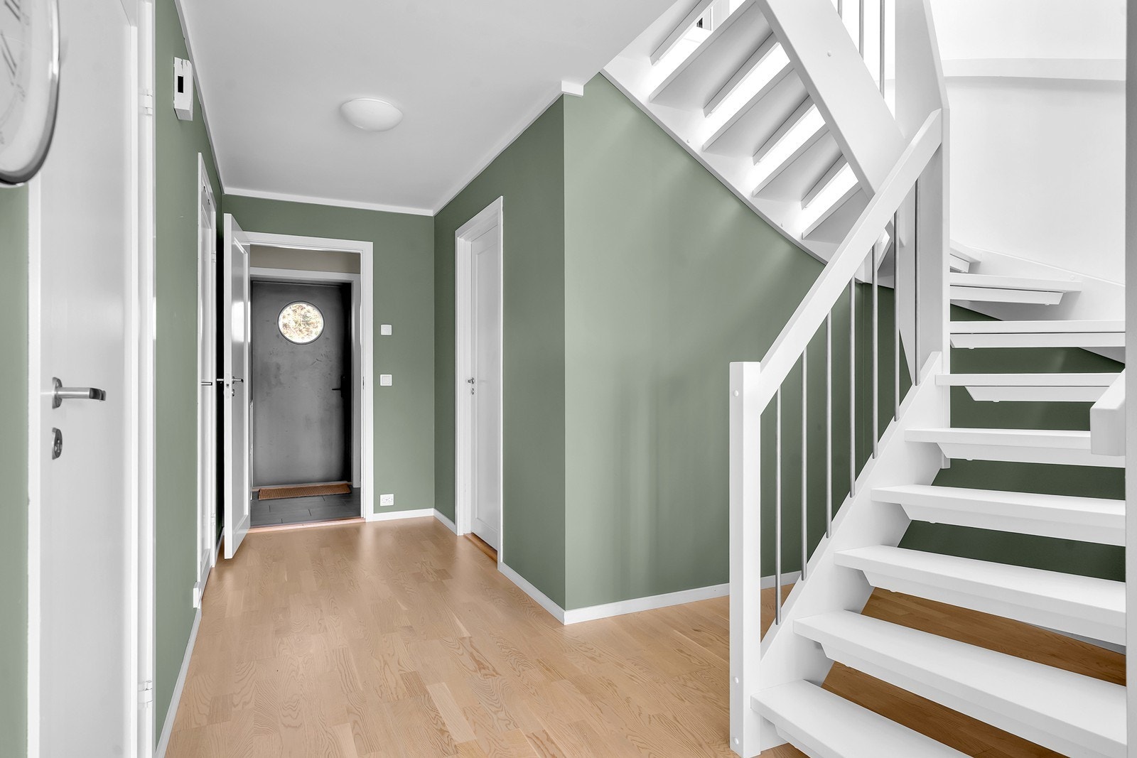 Romslig gang med plass til oppbevaring og praktisk lagringsareal under trappen. Galleribilde