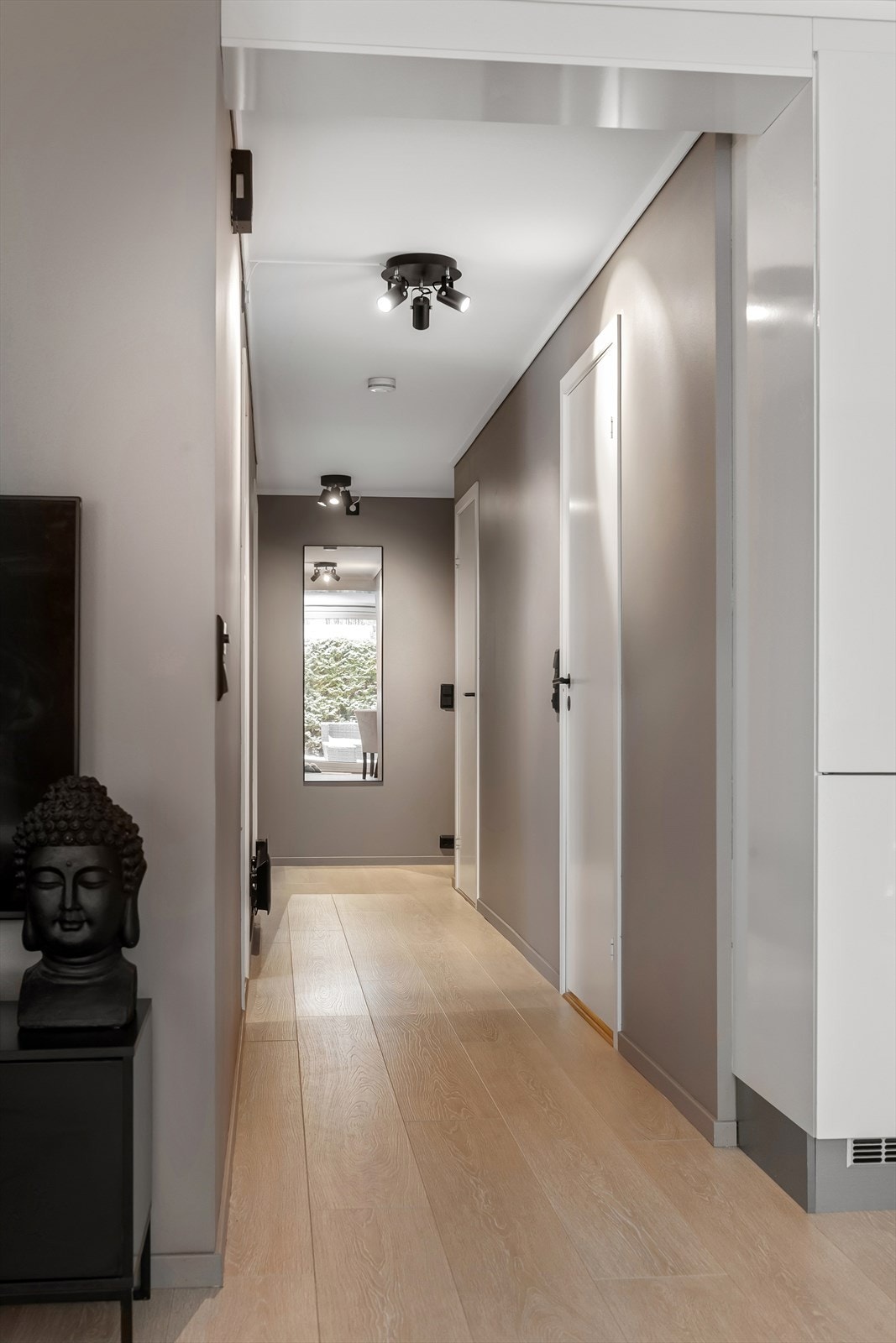 En lys gang med malte, glatte dører leder videre inn i boligen. Galleribilde