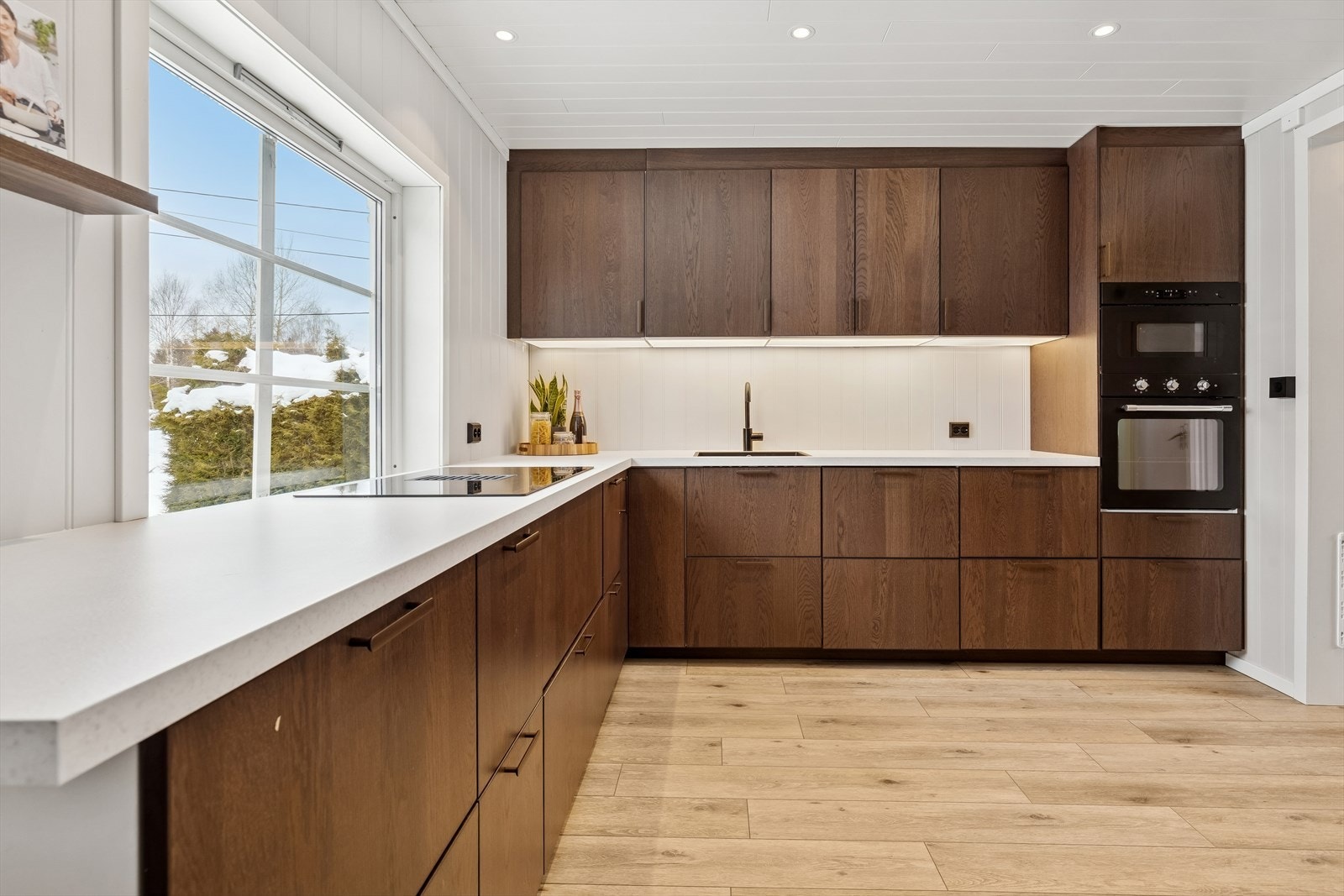 Benkeplaten i laminat har en integrert induksjonstopp med ventilator i senter. Galleribilde