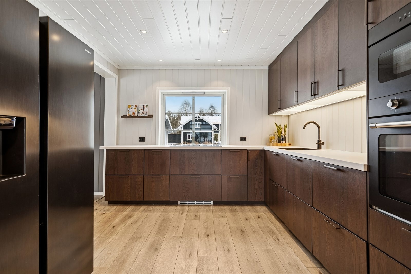 Kjøkkenet er fullt utstyrt med integrerte hvitevarer og et frittstående side-by-side kjøleskap. Galleribilde