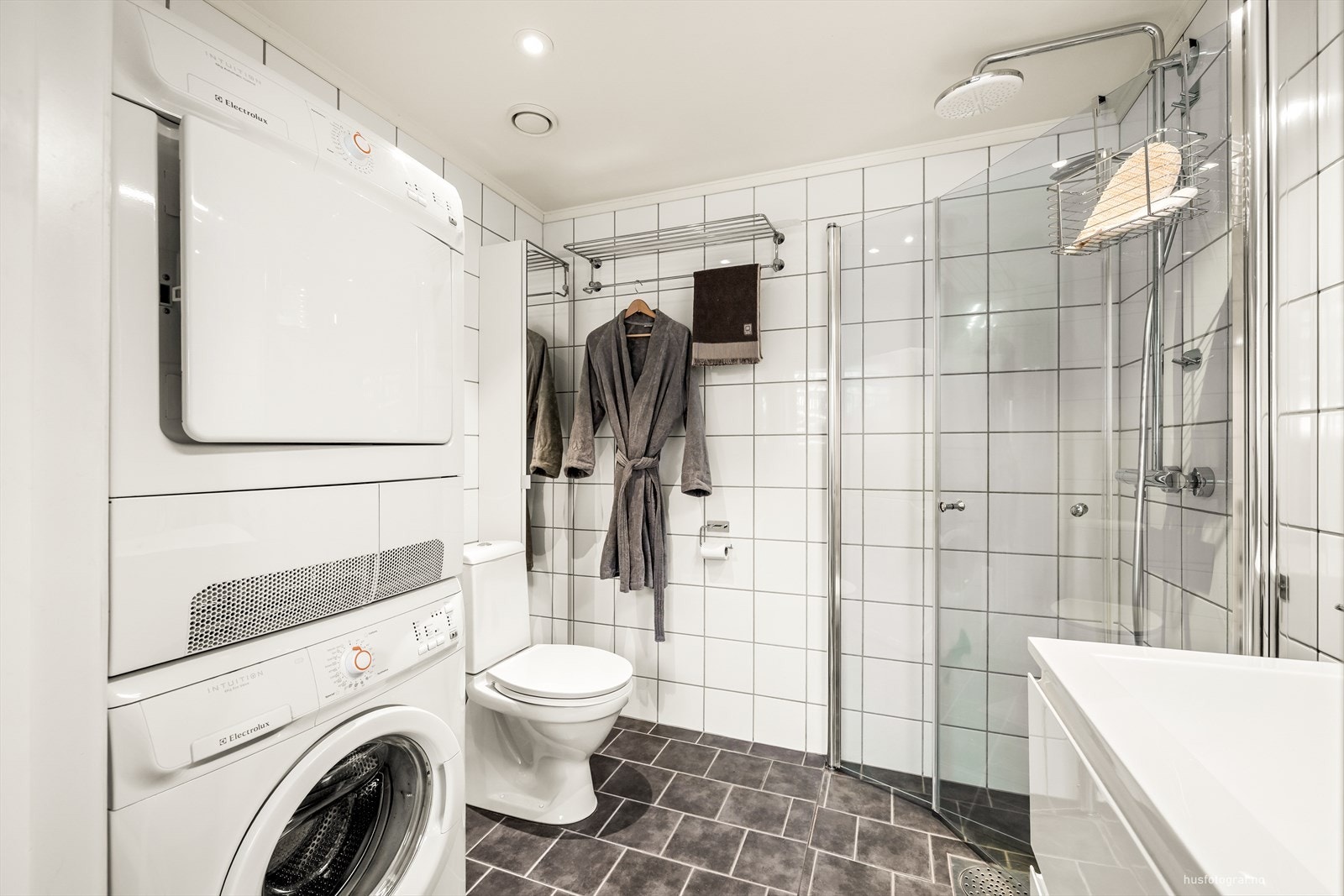 Lekkert bad med grå fliser på gulv og hvite fliser på vegger Galleribilde