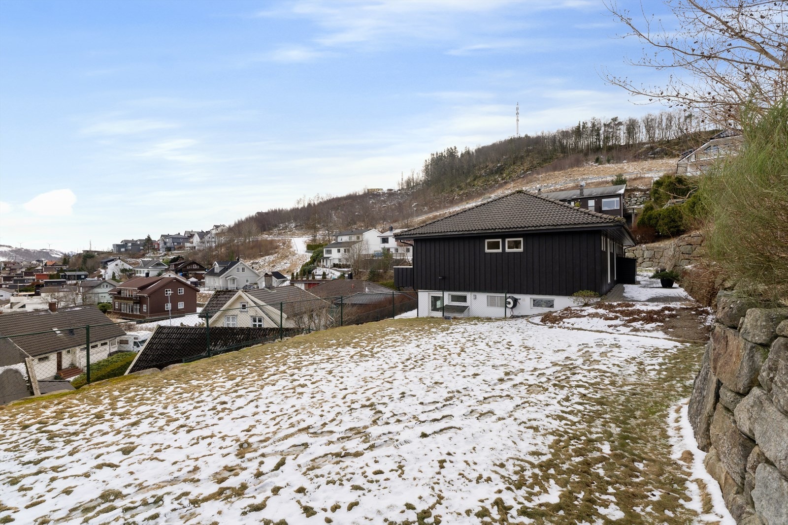 Boligen har en tomt på 771 kvm, hvor deler av hagen er opparbeidet i samarbeid med naboen utover denne eiendommen sine grenser. Tomtegrensa er ved gyvelen. Galleribilde