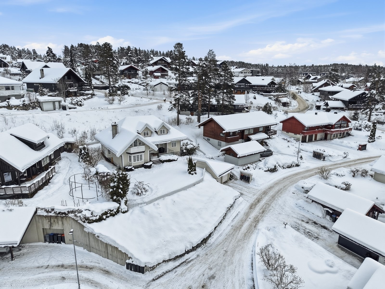Usjenert og privat uteområde, med en flott inngjerdet hage i front. En mindre støttemur mot bilveien, med skråning opp til plenen, som er satt med vedlikeholdsvennlig beplantning. Galleribilde