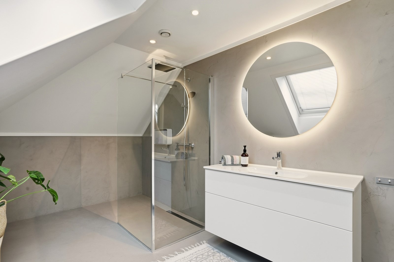 Dusjnisjen fremstår meget romslig, med regndusj og egen ventilasjonskanal over. Det er veggmontert et bakgrunnsbelyst speil, med en klassiske heldekkende servant med skuffinnredning under. Galleribilde