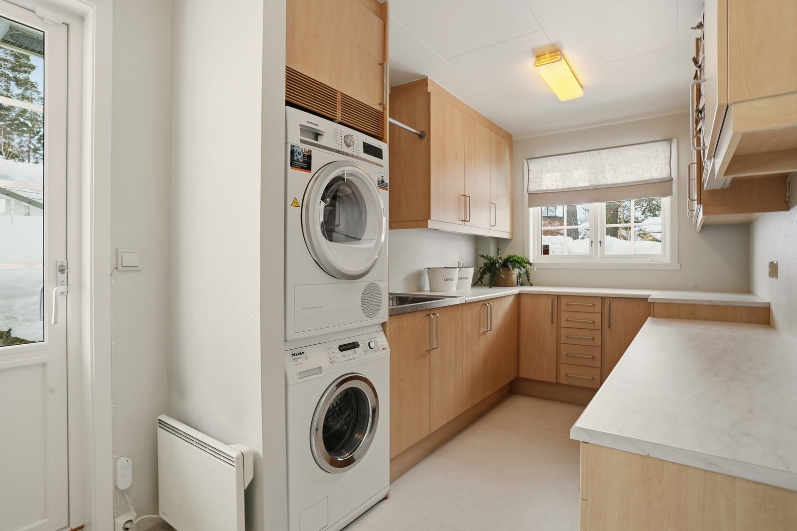 Konvallveien har komforten av å være utstyrt med eget, adskilt vaskerom, et praktisk rom for aktive barnefamilier. Her har man egen sideinngang fra bak boligen, om man kommer inn fra turer, vær og vind. Slitesterke overflater, med mye benkeplass. Galleribilde