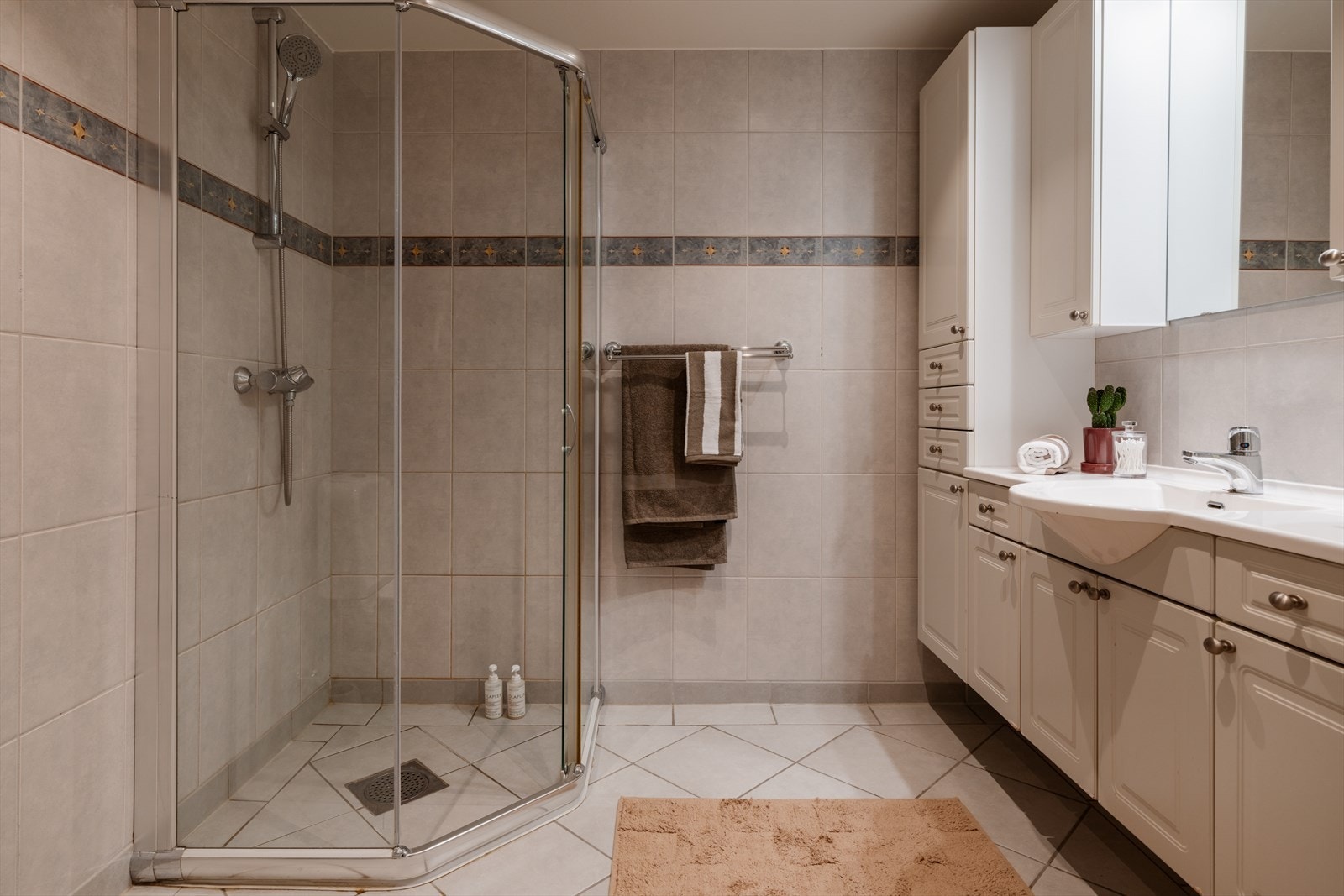 Hovedbadet er helfliset og har en romslig dusjnisje med innfellbare glassdører. Galleribilde