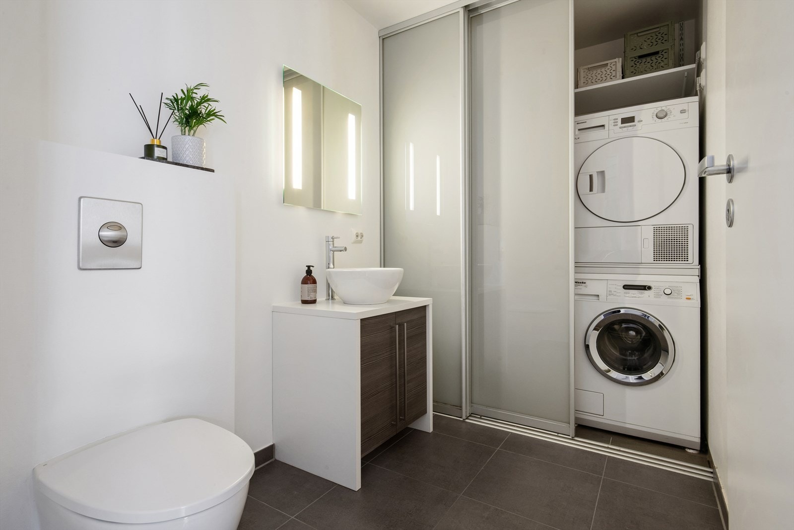 Vaskemaskin og trommel er plassert bak en skyvedør. Galleribilde