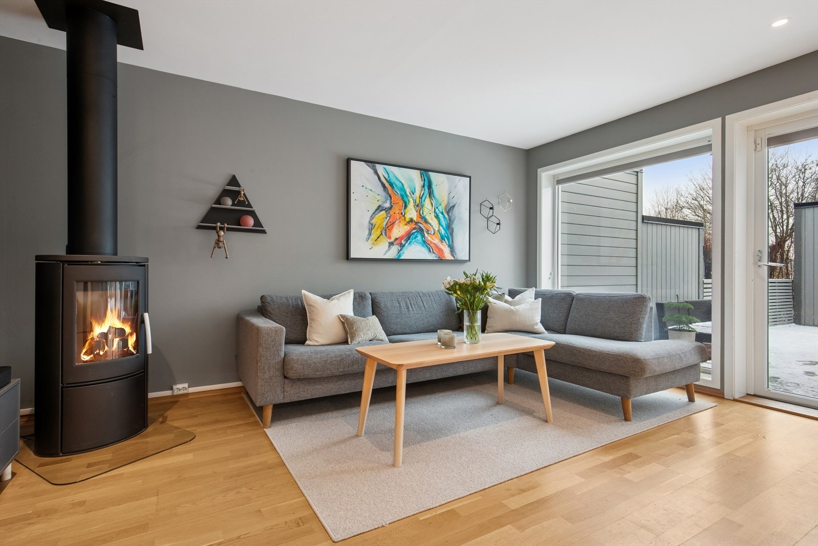 Stuen er lys og luftig med store vindusflater og en flott vedovn. Galleribilde