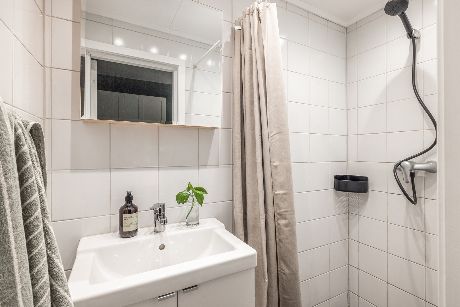 Badet har servant med speil og oppbevaring i tillegg til dusjnisje. Galleribilde