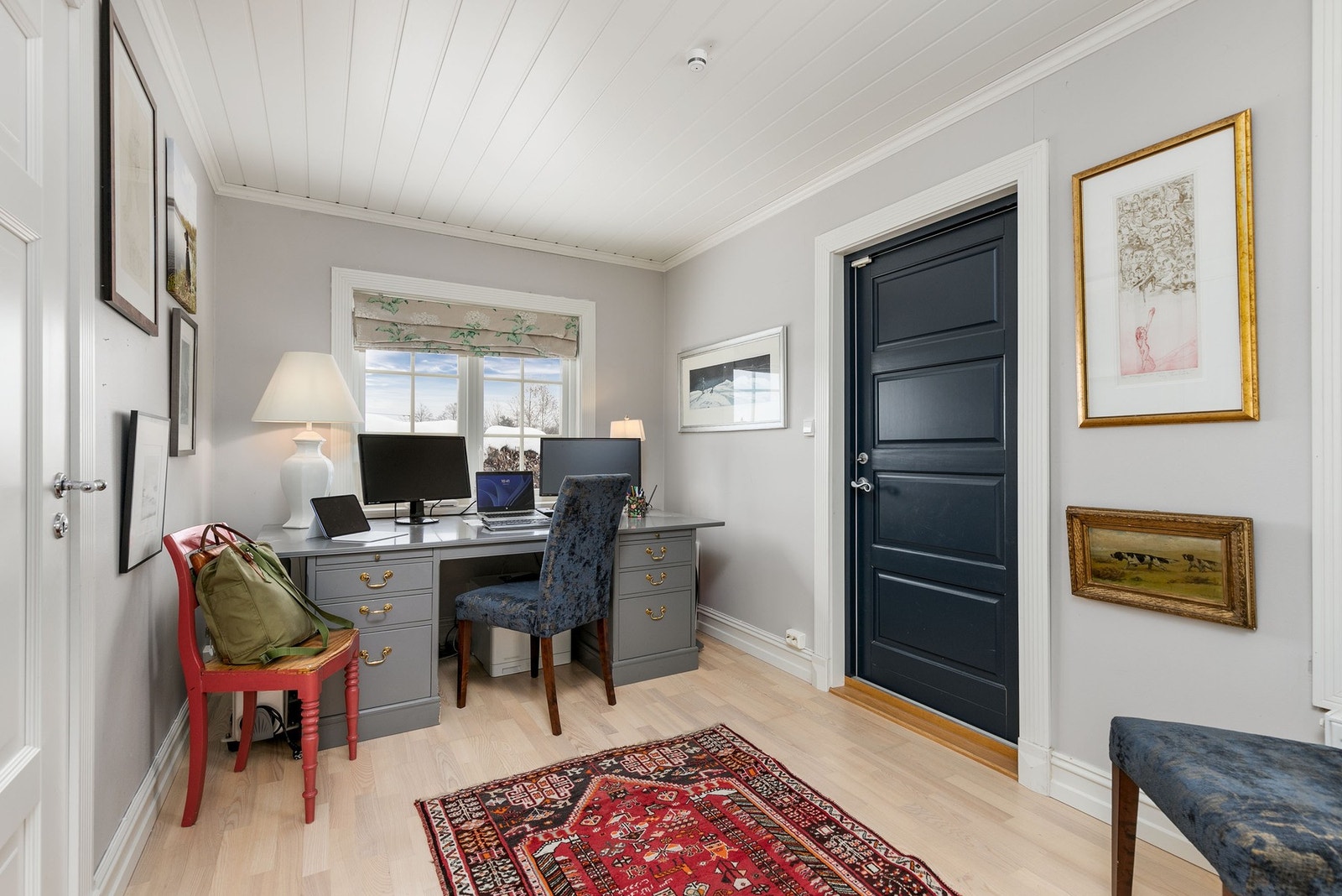 Innenfor TV-stuen ligger et koselig kontor/gjesterom med malte veggflater og parkett på gulv. Galleribilde