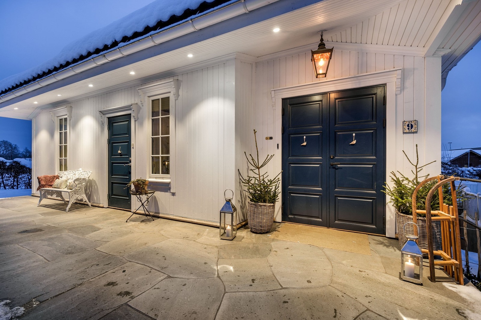 Eiendommen har et imponerende inngangsparti med stor nordvendt skiferbelagt terrasse på ca. 24 m², tilgjengelig via en støpt trapp med rekkverk i sort smijern. Galleribilde