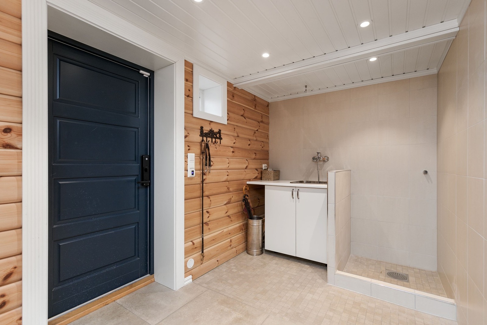 Det er etablert skiferlagt adkomst til kjeller og varmekabler i trapp og ved kjellerinngang. I gangen er det etablert praktisk hundedusj. Galleribilde