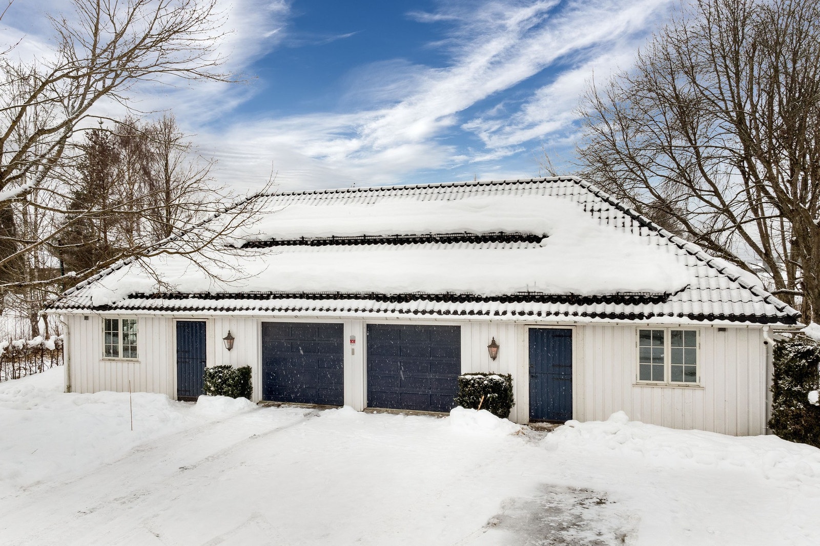Eiendommen har parkering i et stort frittstående garasjebygg på 166 m² BRA-e. Det er installert 1 stk. elbillader. Galleribilde