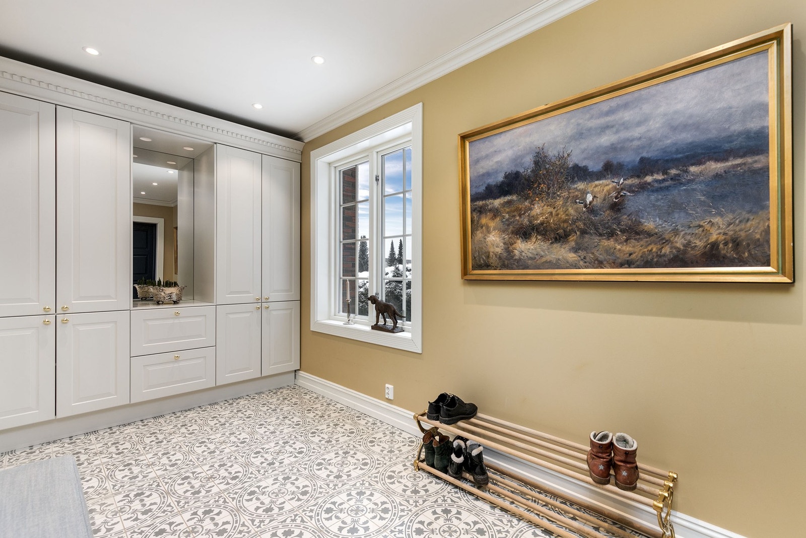 En vakker og romslig hall ønsker deg velkommen inn i denne klassiske og ærverdige villaen. Det er etablert en flott garderobeløsning fra Sigdal med innfelt belysning og speil. Galleribilde