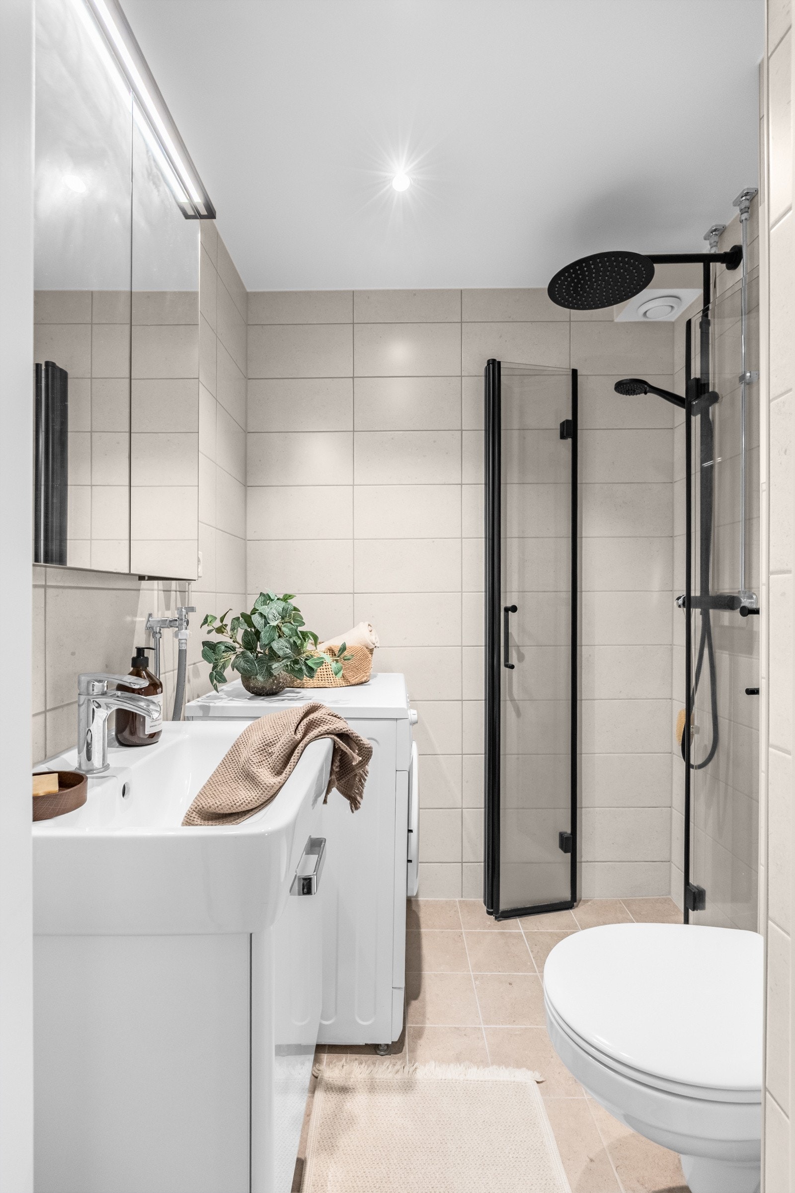 Innredningen består av dusjhjørne med regnfallsdusj, speilskap med overlys, vegghengt toalett og opplegg for vaskemaskin. Galleribilde