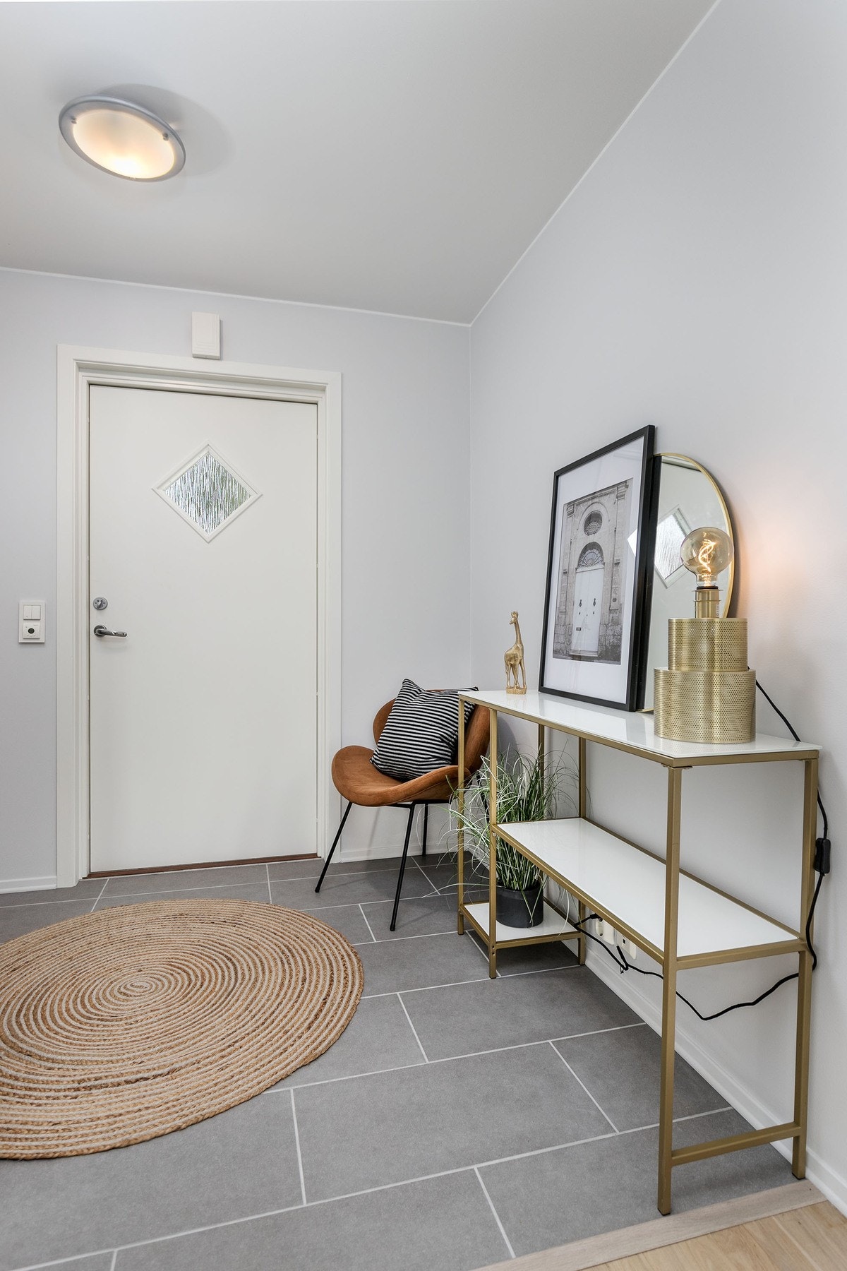 Lys og innbydende entre med delikate storformatfliser på gulv med gulvvarme, som gir et godt førsteinntrykk av leiligheten. Galleribilde