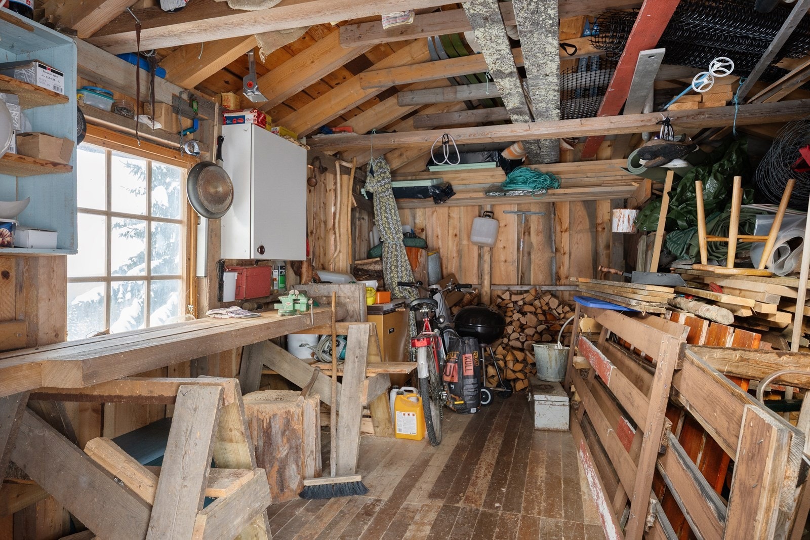 Uthuset på 17 m² gir rikelig med lagringsplass for ski, ved og utstyr. Galleribilde
