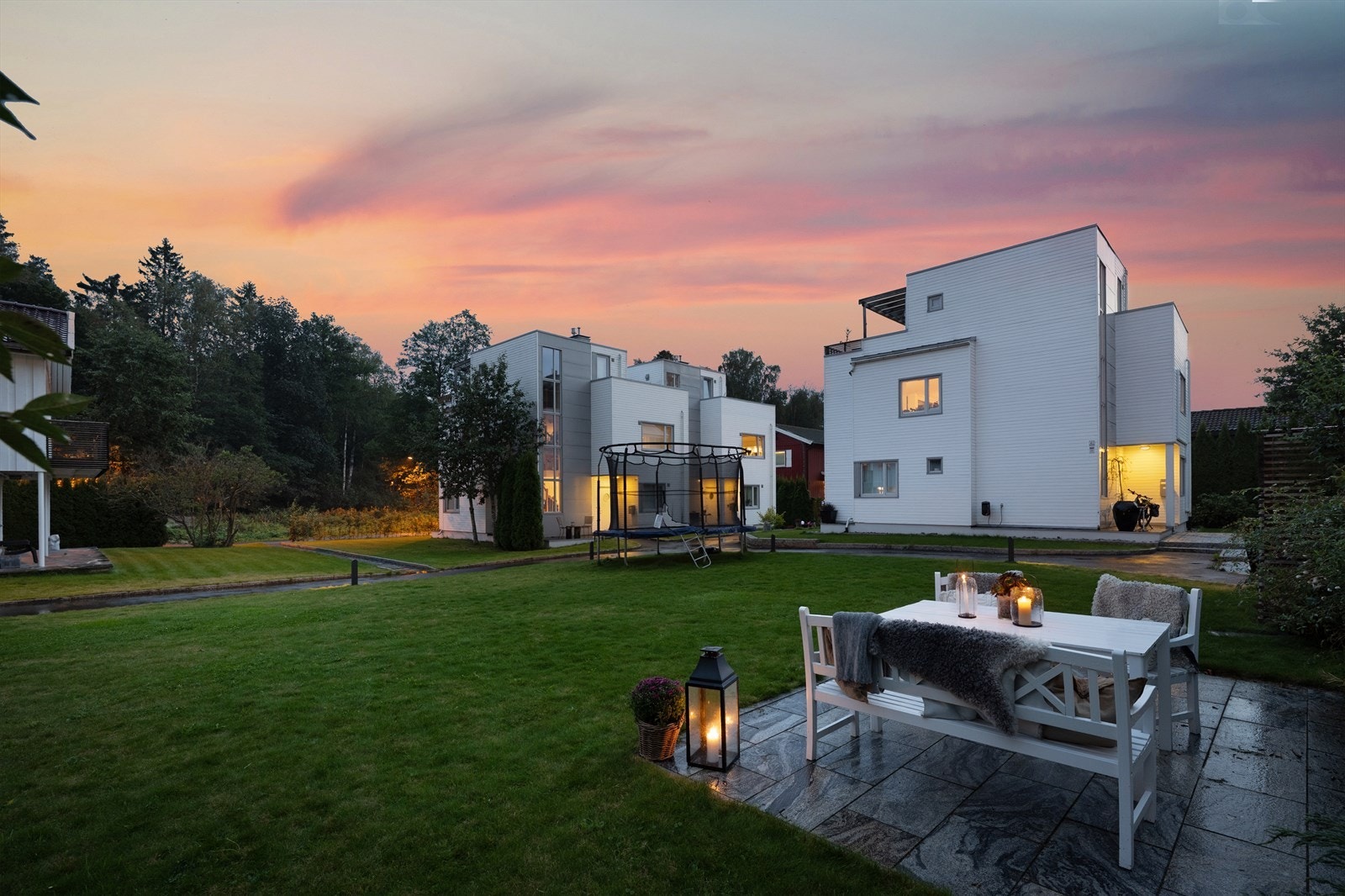 Fellesarealene er flott opparbeidet med gressplener og beplanting, samt uteplass med sittegruppe og felles trampoline Galleribilde