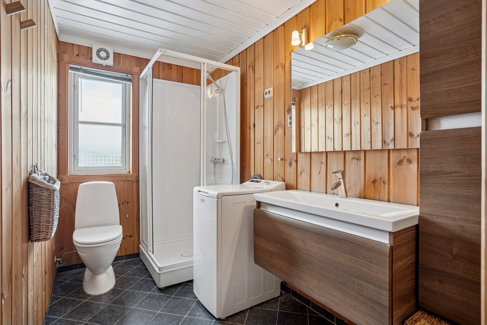 Praktisk bad med dusjkabinett, moderne innredning og opplegg for vaskemaskin. Galleribilde