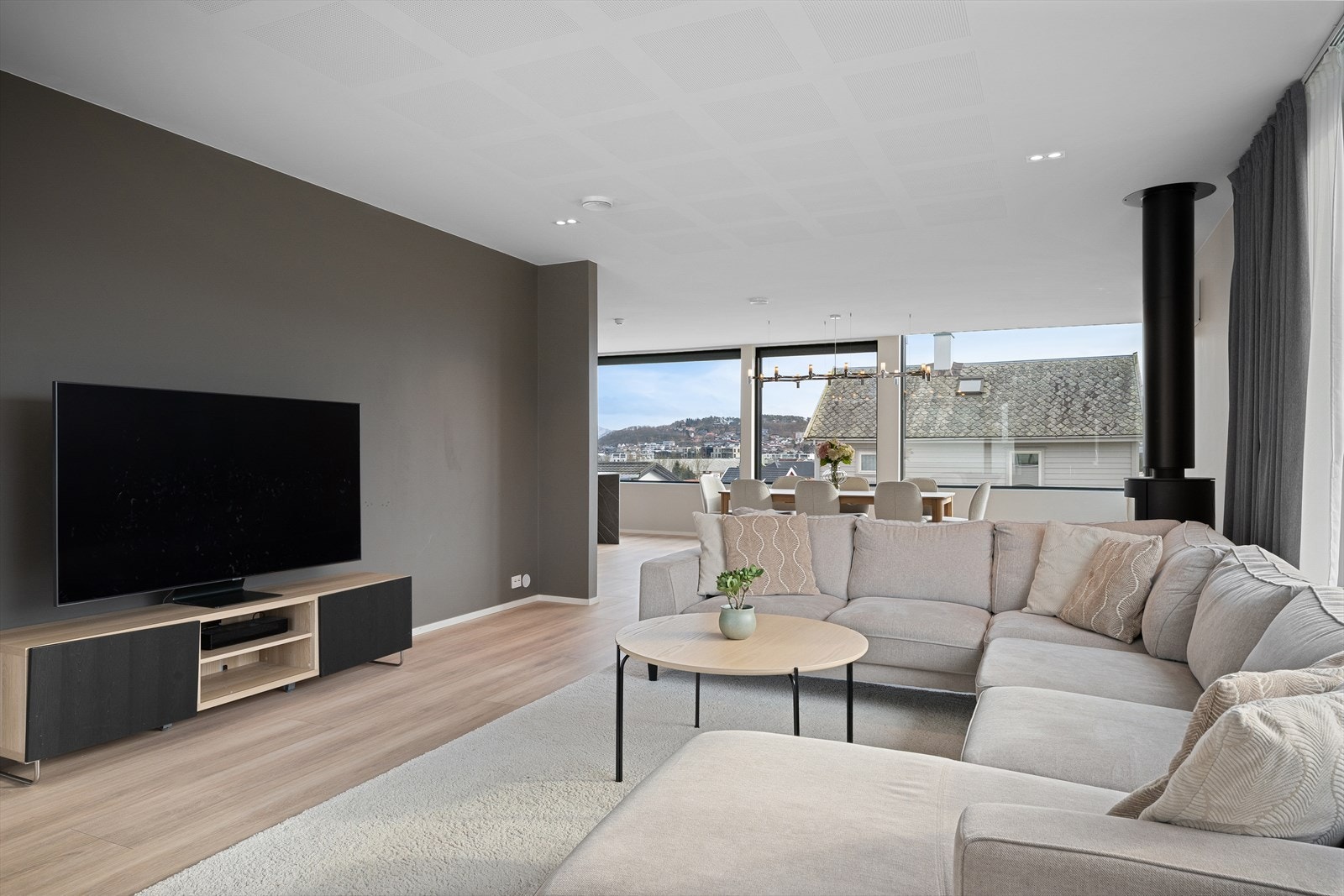 En deilig stue m/mye naturlig lys, store møbleringssoner og fin flyt. Lyddempende takplater. Varmepumpe for jevn temperatur, og peisovn for de kaldeste dagene og kosen. Galleribilde